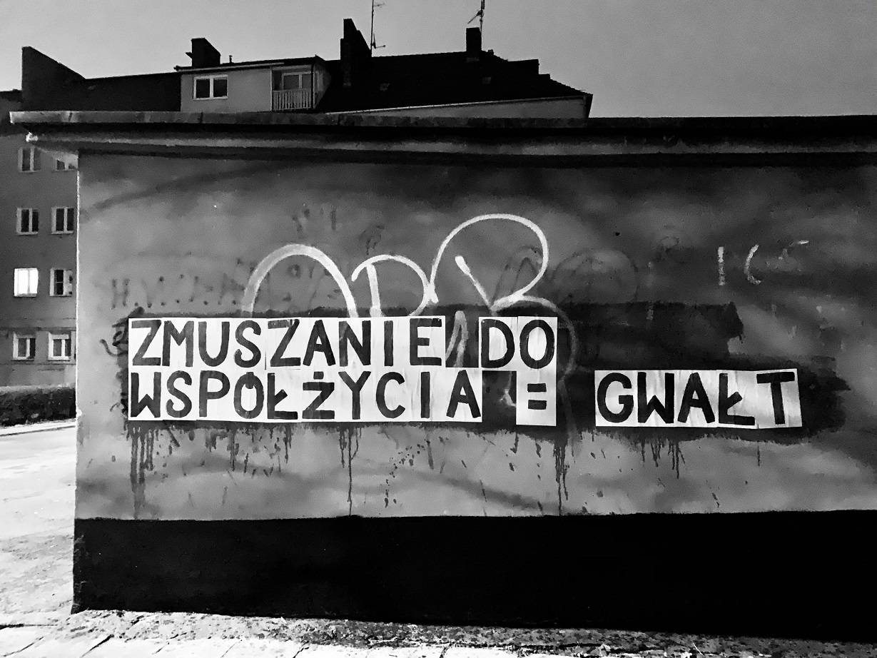Napis z plakatów na murze: "Zmuszanie do współżycia = gwałt"