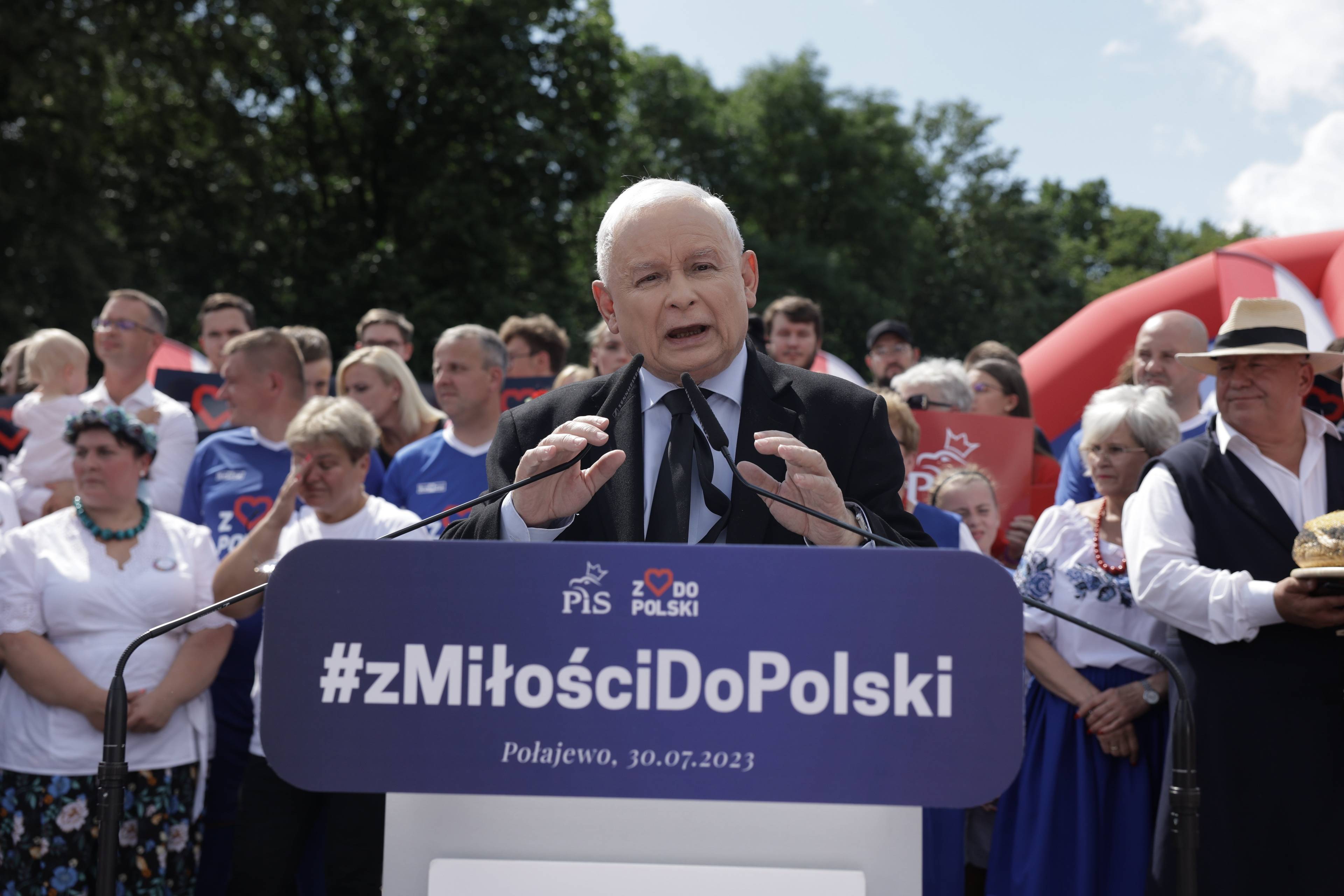 Kaczyński przemawia gestykulując, za nim tłum