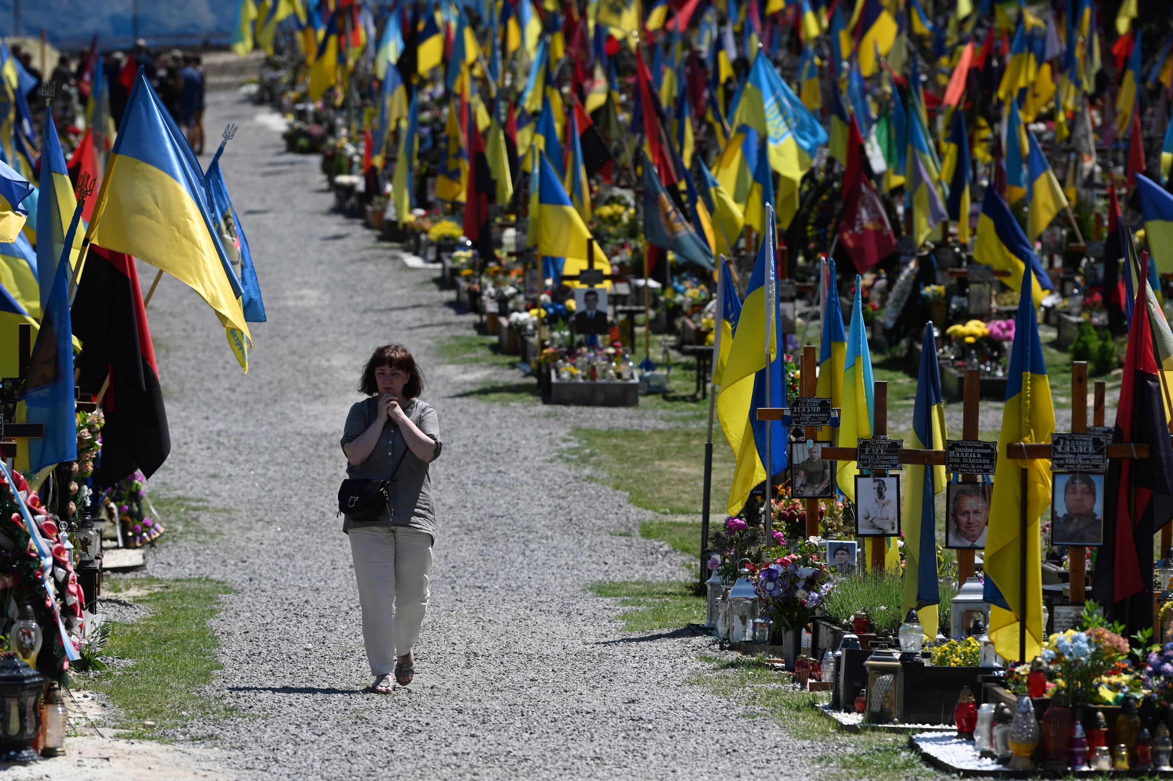 cmentarz żołnierzy ukraińskich, miedzy mogiłami, główną aleją idzie kobieta