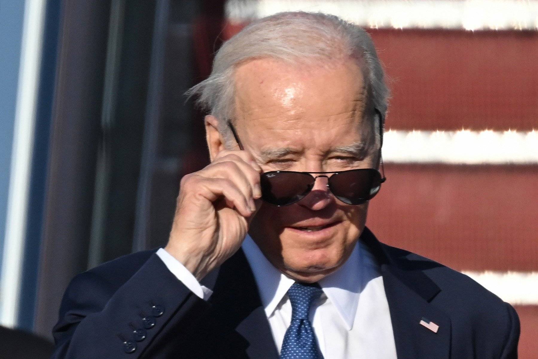 Starszy mężczyzna patrzy ponad okularami słonecznymi, prezydent Biden