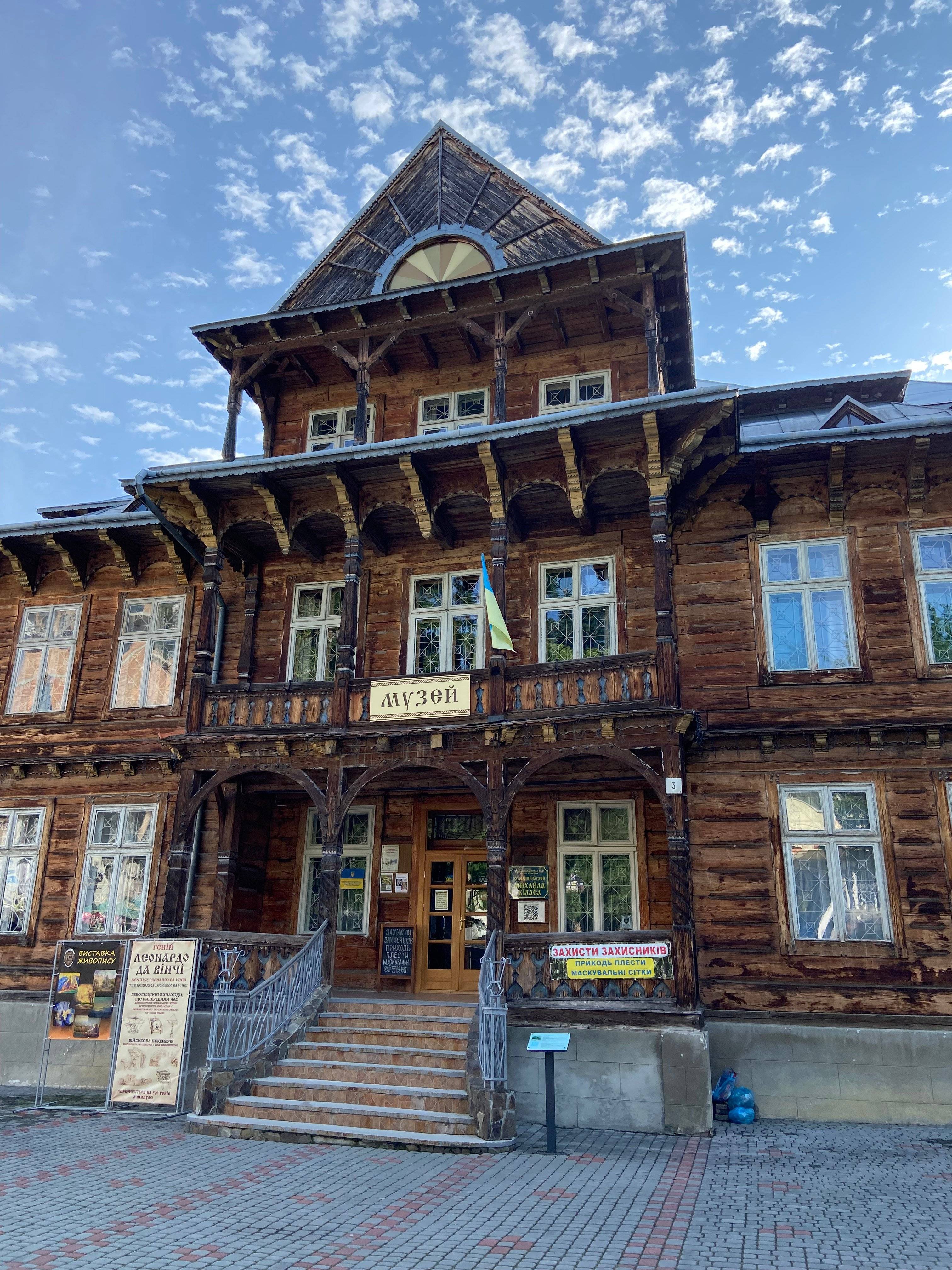 wysoki, drewniany budynek z napisem po ukraińsku "Muzeum"