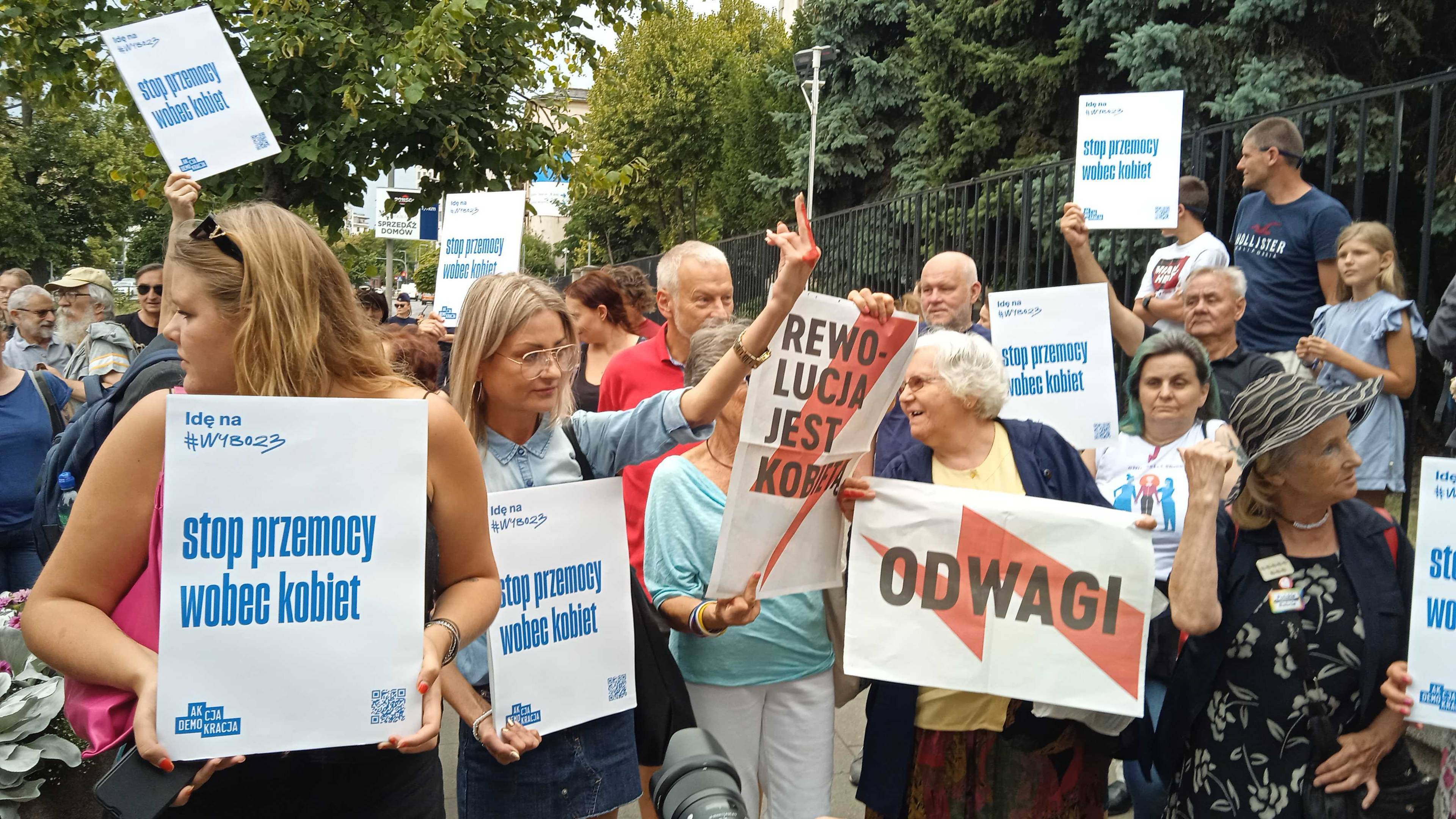 Demonstracja solidarnościowa z panią Joanną w Warszawie. Na zdjęciu osoby z plakatami z napisem "Odwagi" oraz "Stop przemocy wobec kobiet"