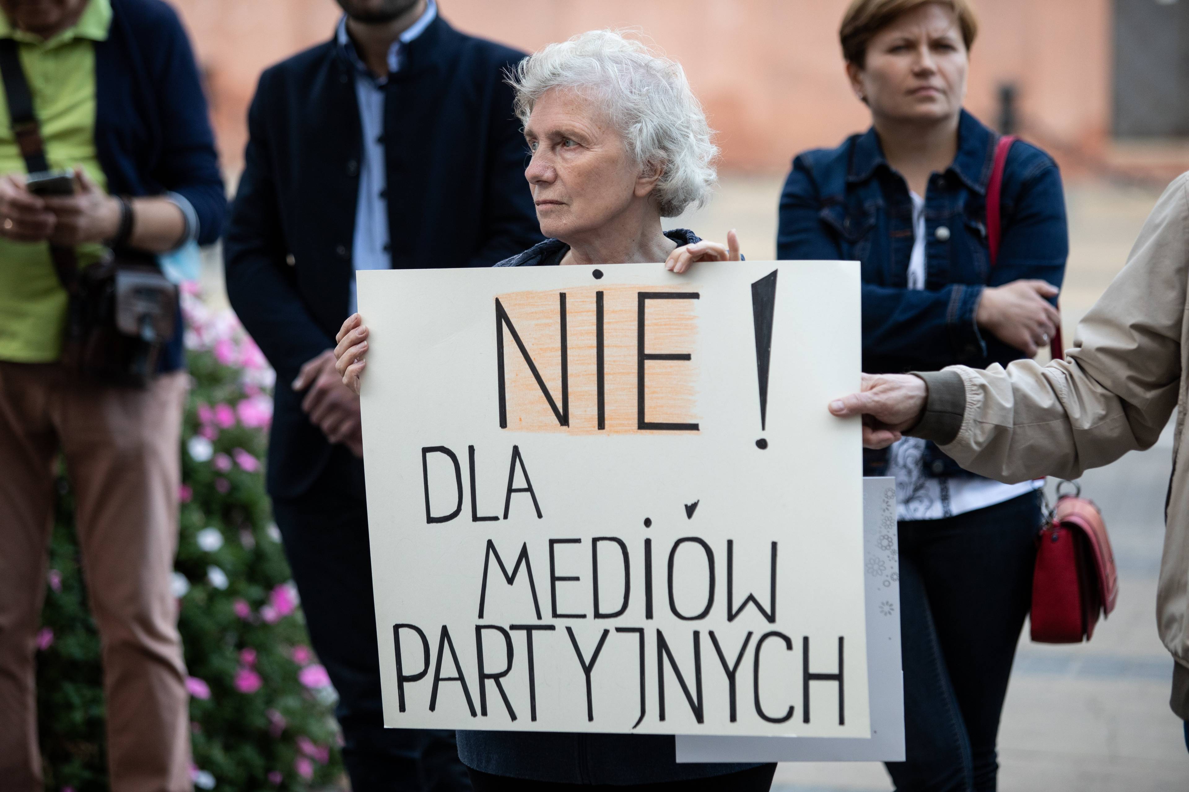 Protest, kobieta z banerem Nie dla mediów partyjnych