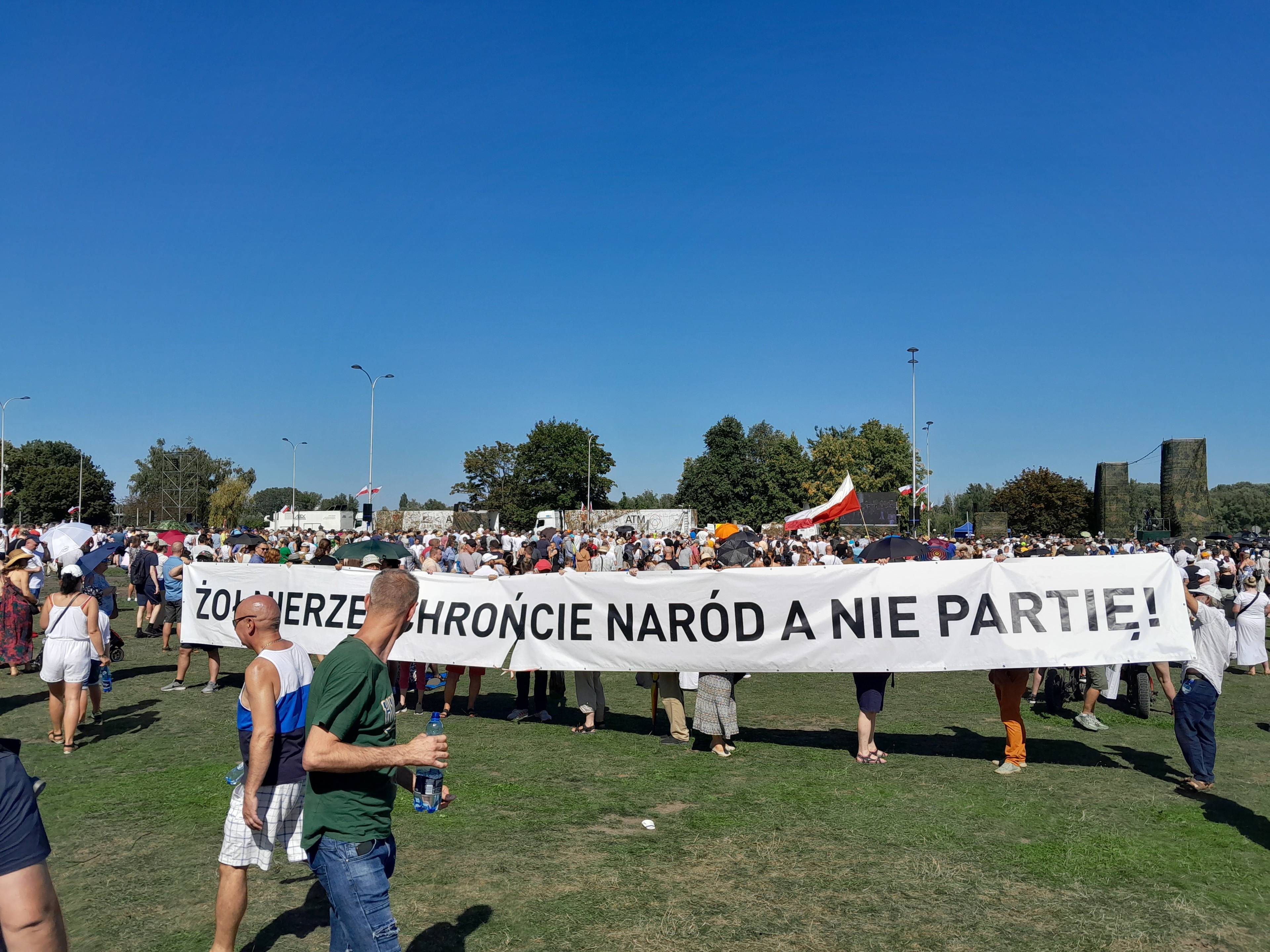 grupa osób trzyma transparent z napisem "żołnierze chrońcie naród a nie partię"