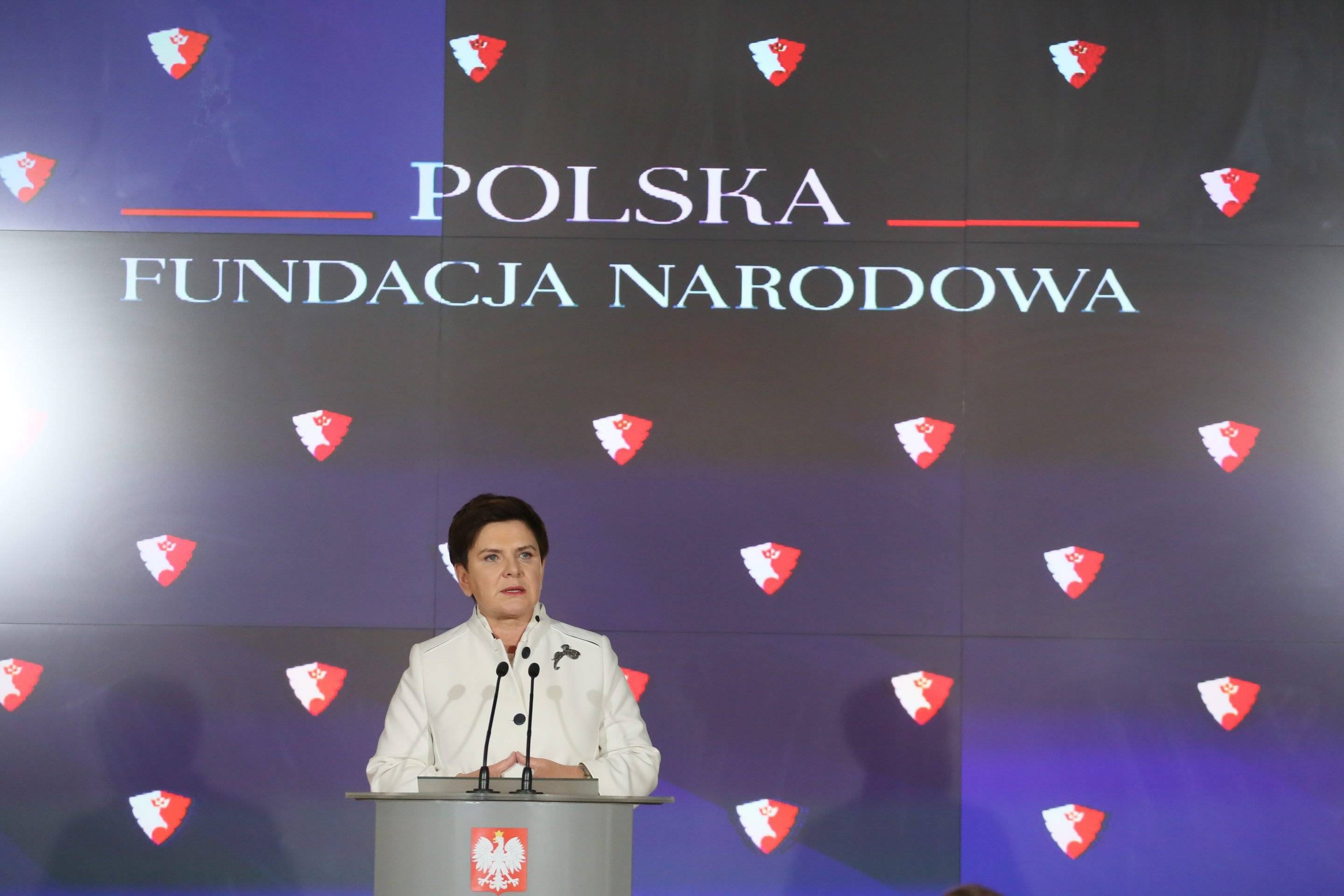 Beata Szydło przemawia przy pulpicie, w tle napisa Polska Fundacja Narodowa