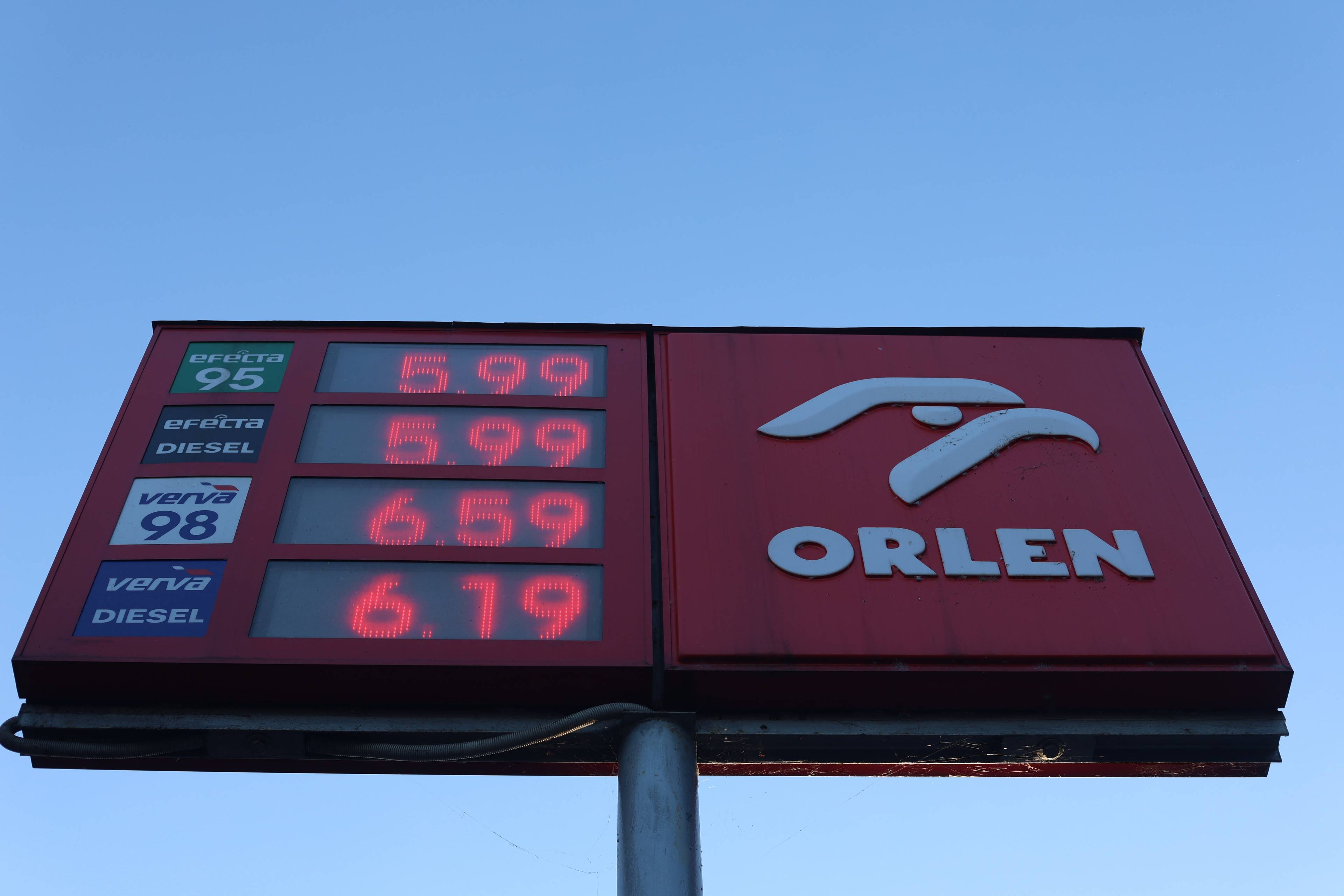Tablica z cenami paliw Orlenu na tle niebieskiego, bezchmurnego nieba. Cena oleju napędowego to 5,99 zł