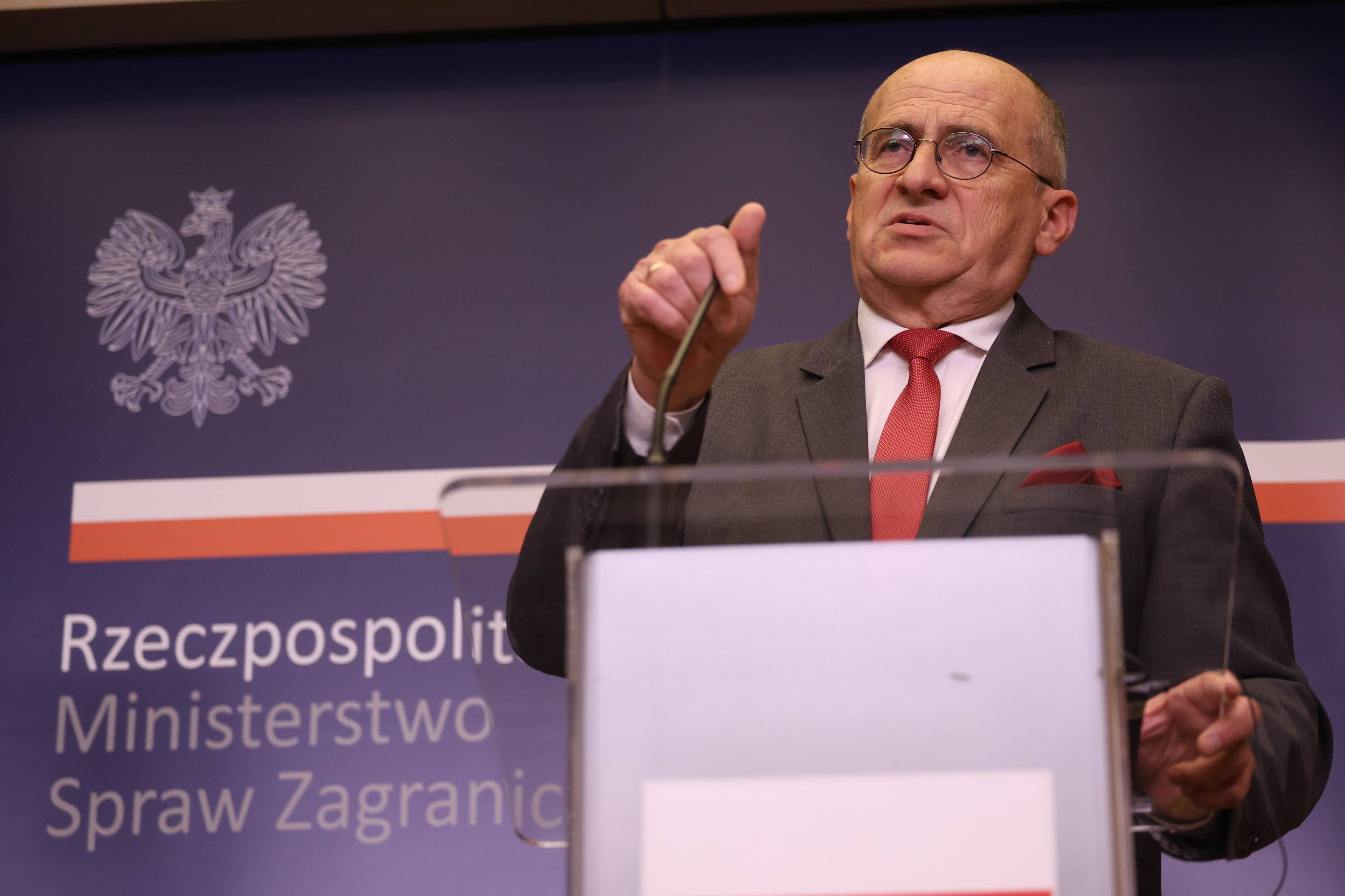 Minister spraw zagranicznych Zbigniew Rau przemawia przed pulpitem, na tle napisu "Ministerstwo Spraw Zagranicznych"