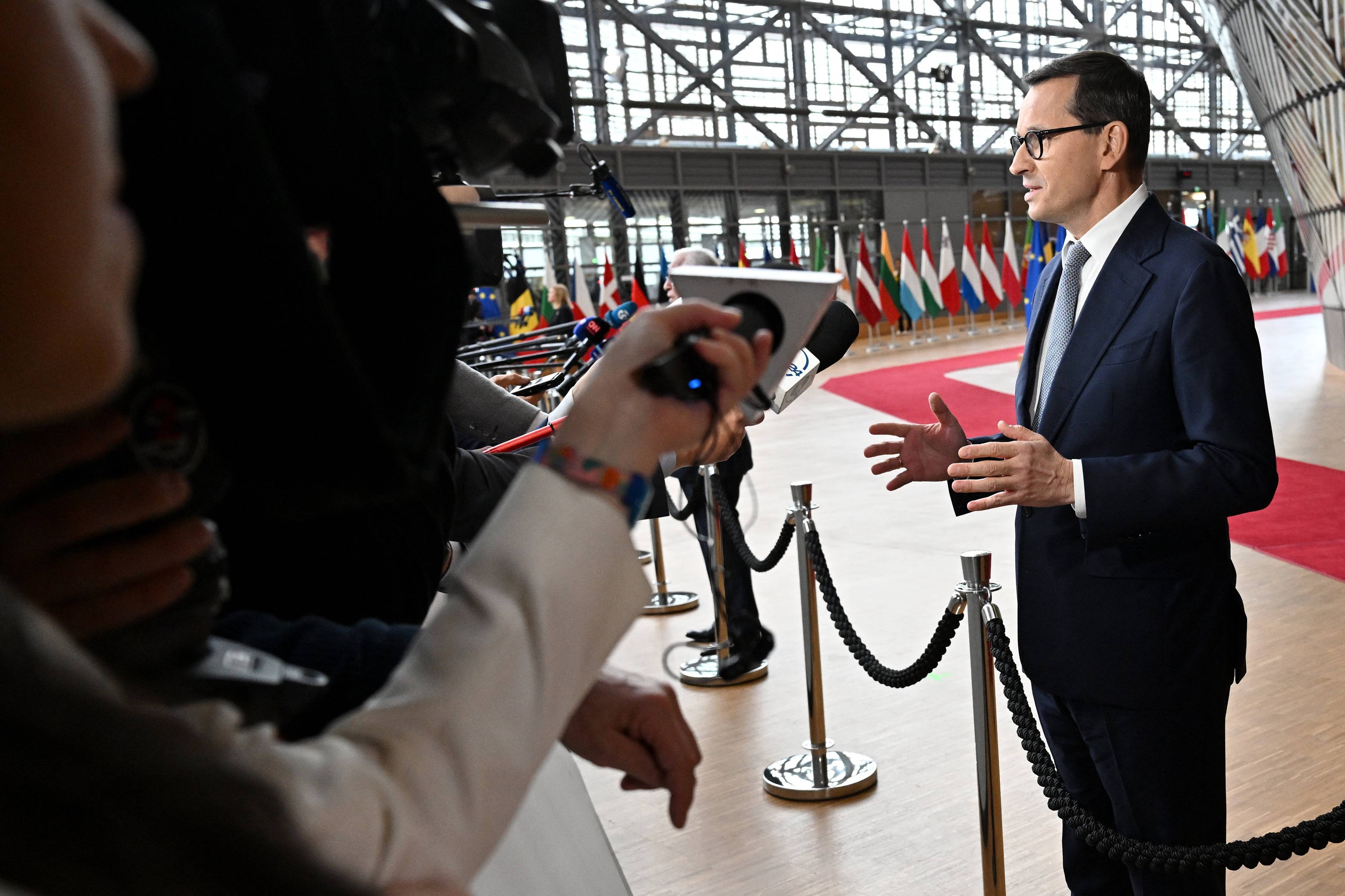 Mateusz Morawiecki przed mikrofonami mediów na szczyciu UE w Brukseli