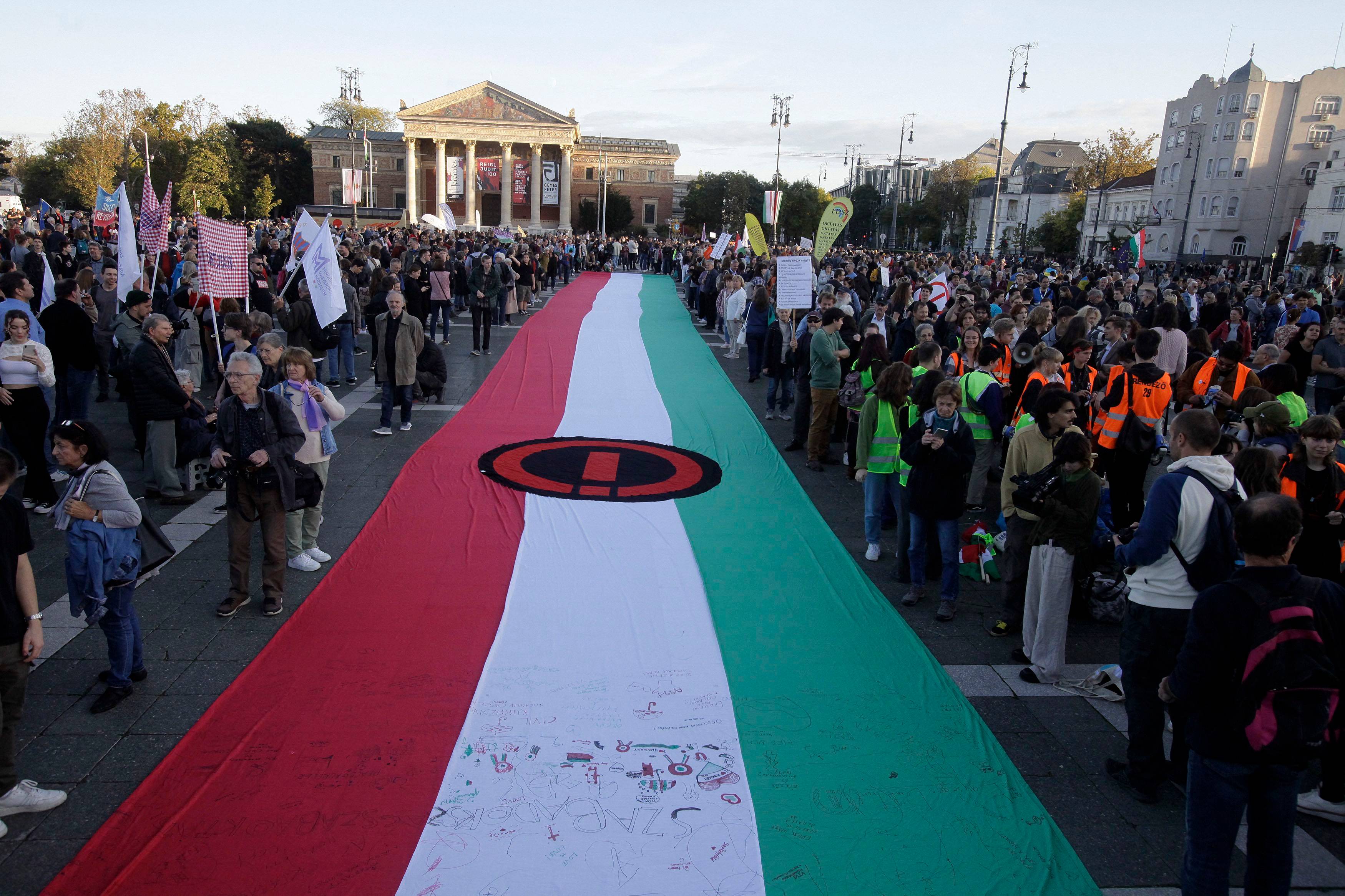 Wielka flaga węgierska w kolorze czerwono-biało-zielonym niesiona przez uczestników demonstracji