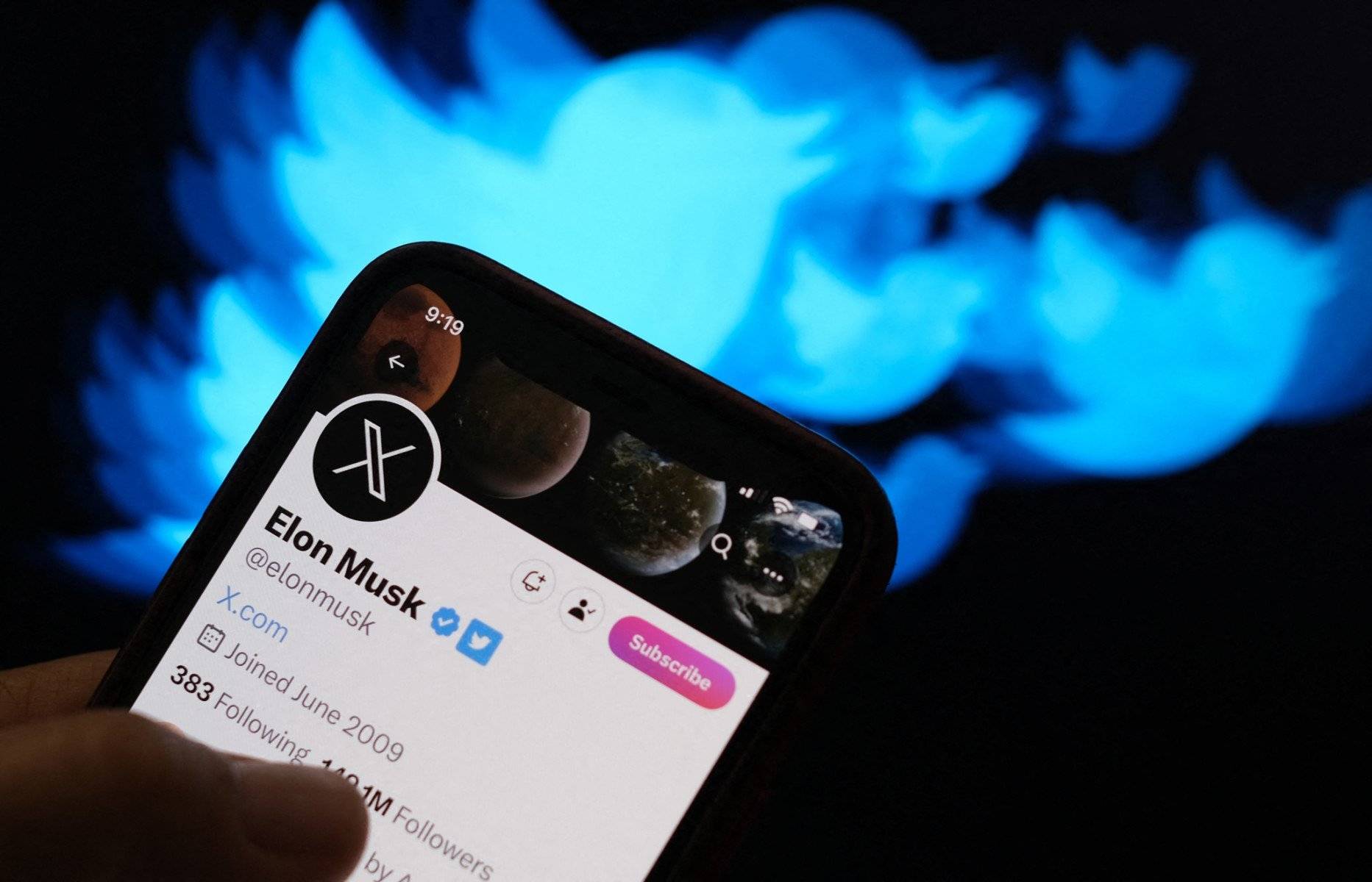 This illustration photo created in Los Angeles, California, on July 24, 2023, shows the Twitter bird logo in the background of the Twitter page of Elon Musk, advertising a possible X as a replacement Twitter logo. Elon Musk killed off the Twitter logo on July 24, 2023, replacing the world-recognized blue bird with a white X as the tycoon accelerates his efforts to transform the floundering social media giant. Musk and the company's new chief executive Linda Yaccarino announced the rebranding on July 23, 2023, scrapping one of technology's most iconic brands in the latest shock move since the tycoon took over Twitter nine months ago. (Photo by Chris Delmas / AFP)