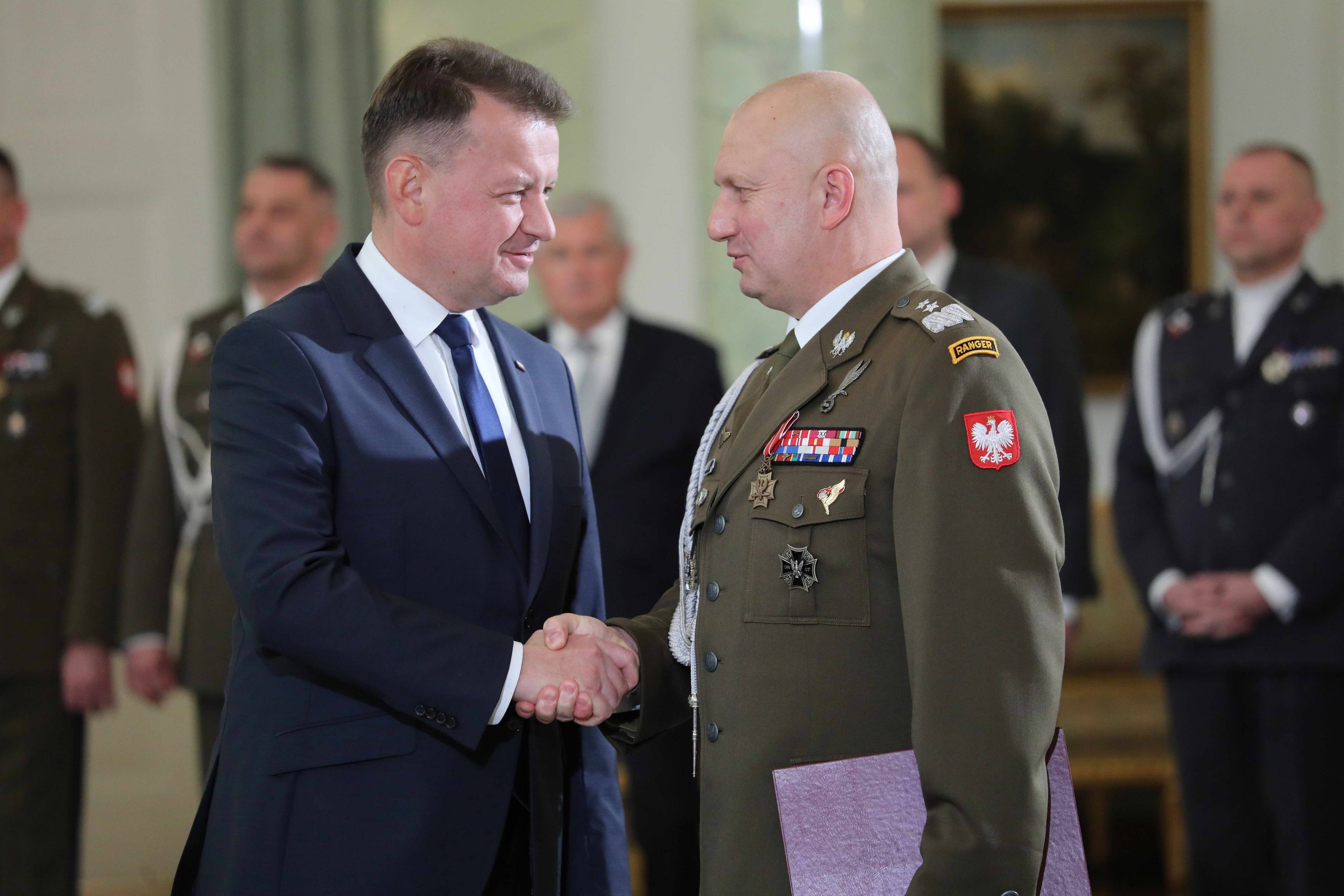 Minister Mariusz Błaszczak ściska rękę generała Macieja Klisza w Pałacu Prezydenckim.