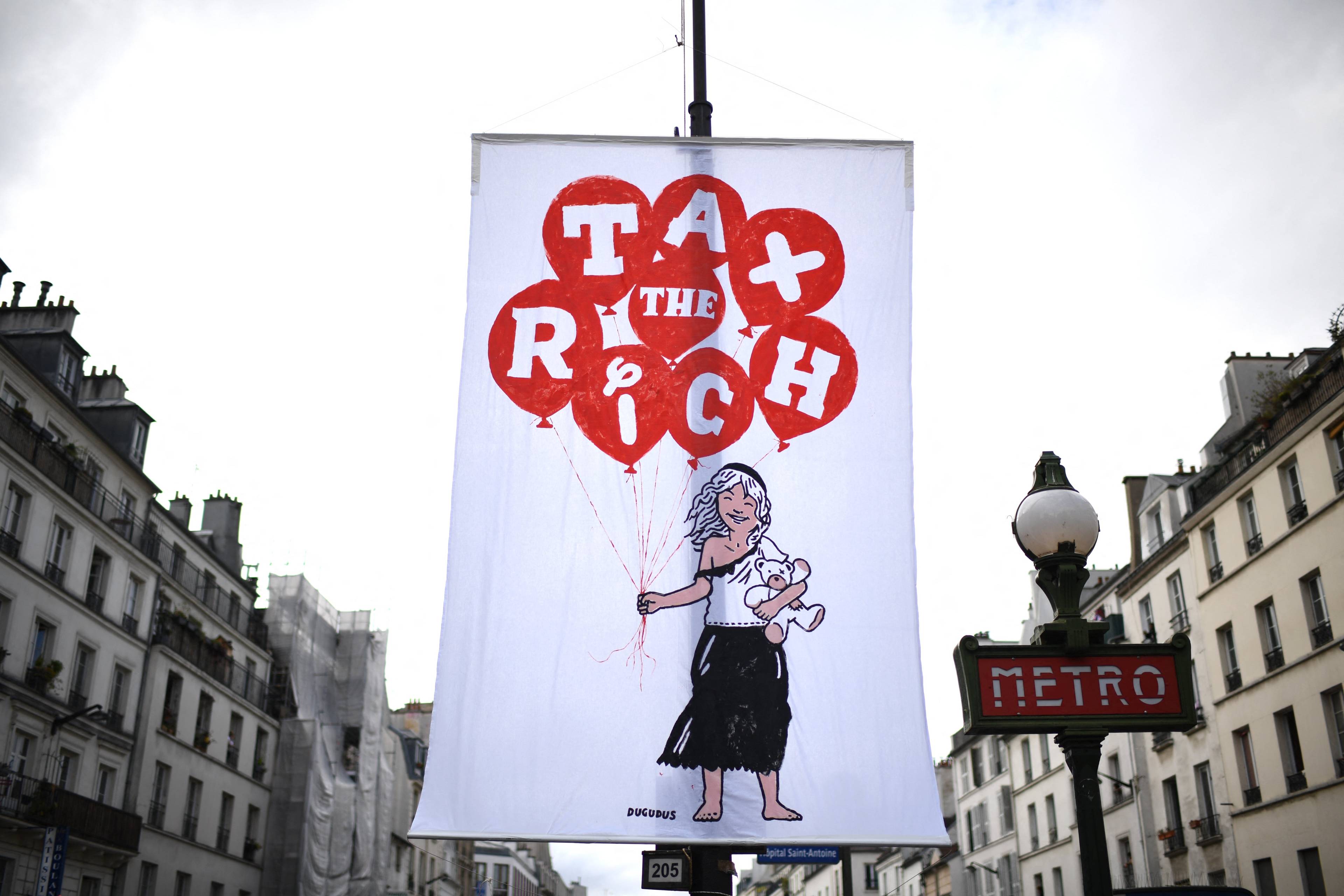 Baner z napisem "Opodatkować bogatych" wisi przy francuskiej ulicy