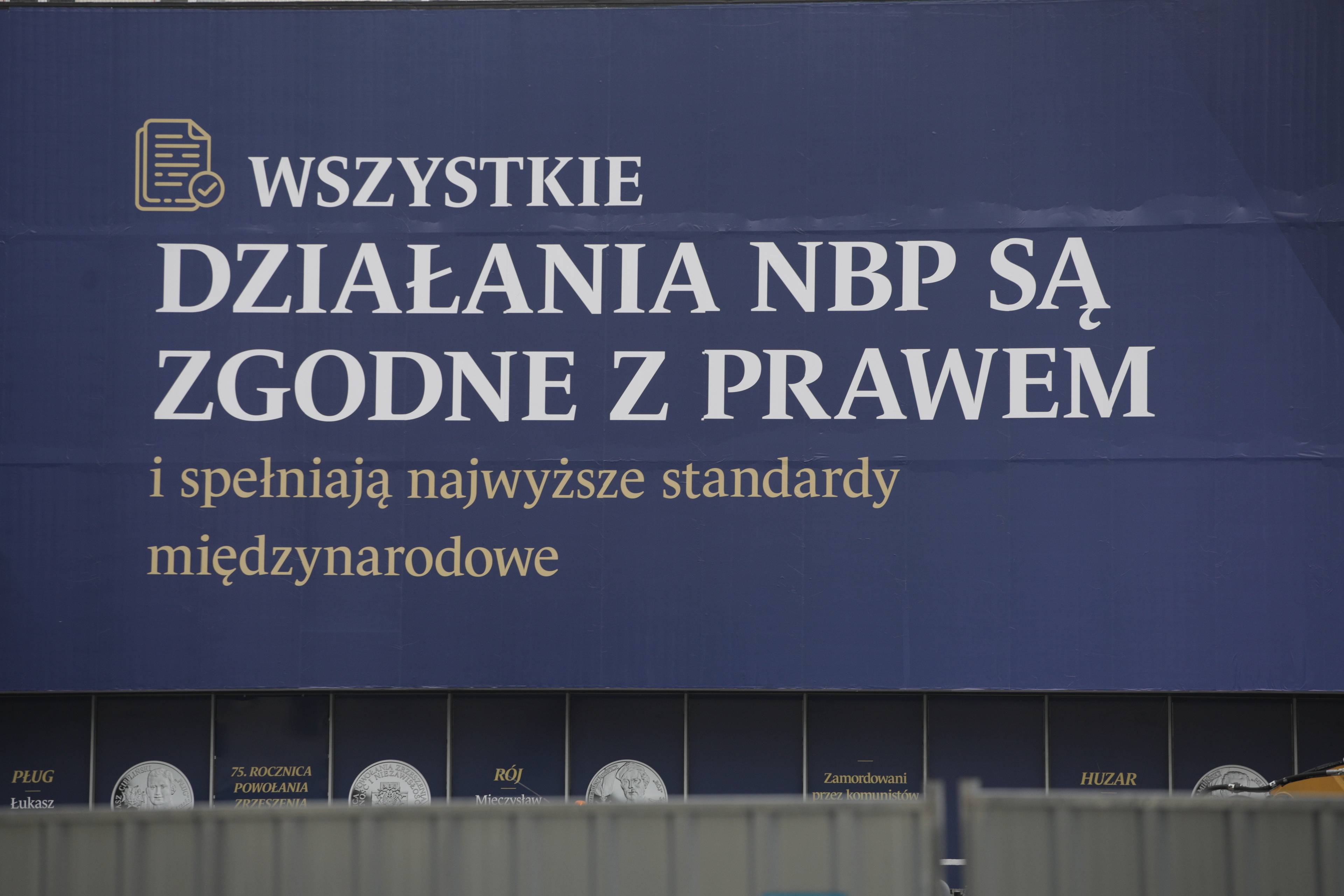 Napis na siedzibie NBP na niebieskim tle: "Wszystkie działania NBP są zgodne z prawem i spełniają najwyższe standardy międzynarodowe"