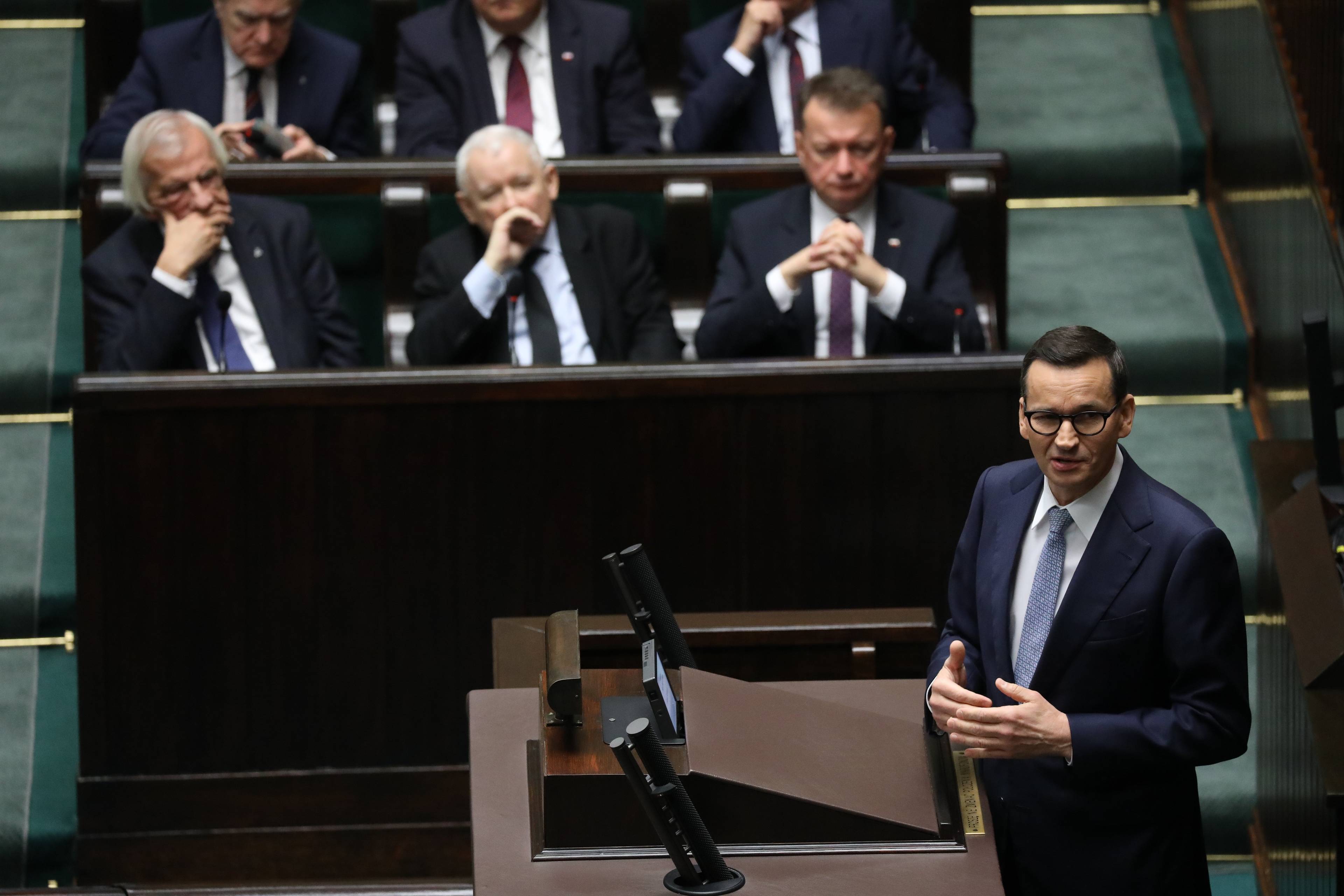 Morawiecki na mównicy Sejmowej, za nim siedzą Błaszczak, Kaczyński i Terlecki