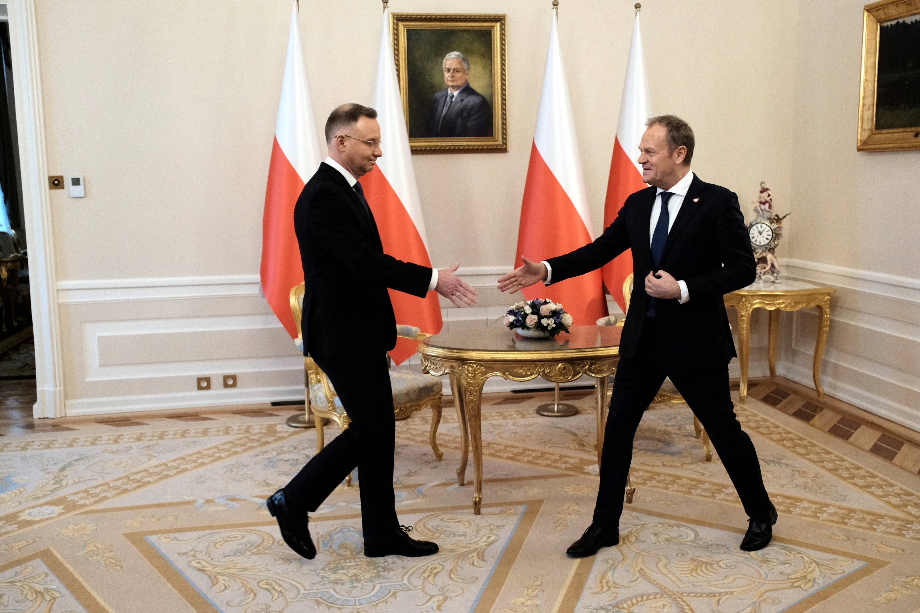 Andrzej Duda i Donald Tusk uchwyceni w kadrze tuż przed podaniem sobie rąk