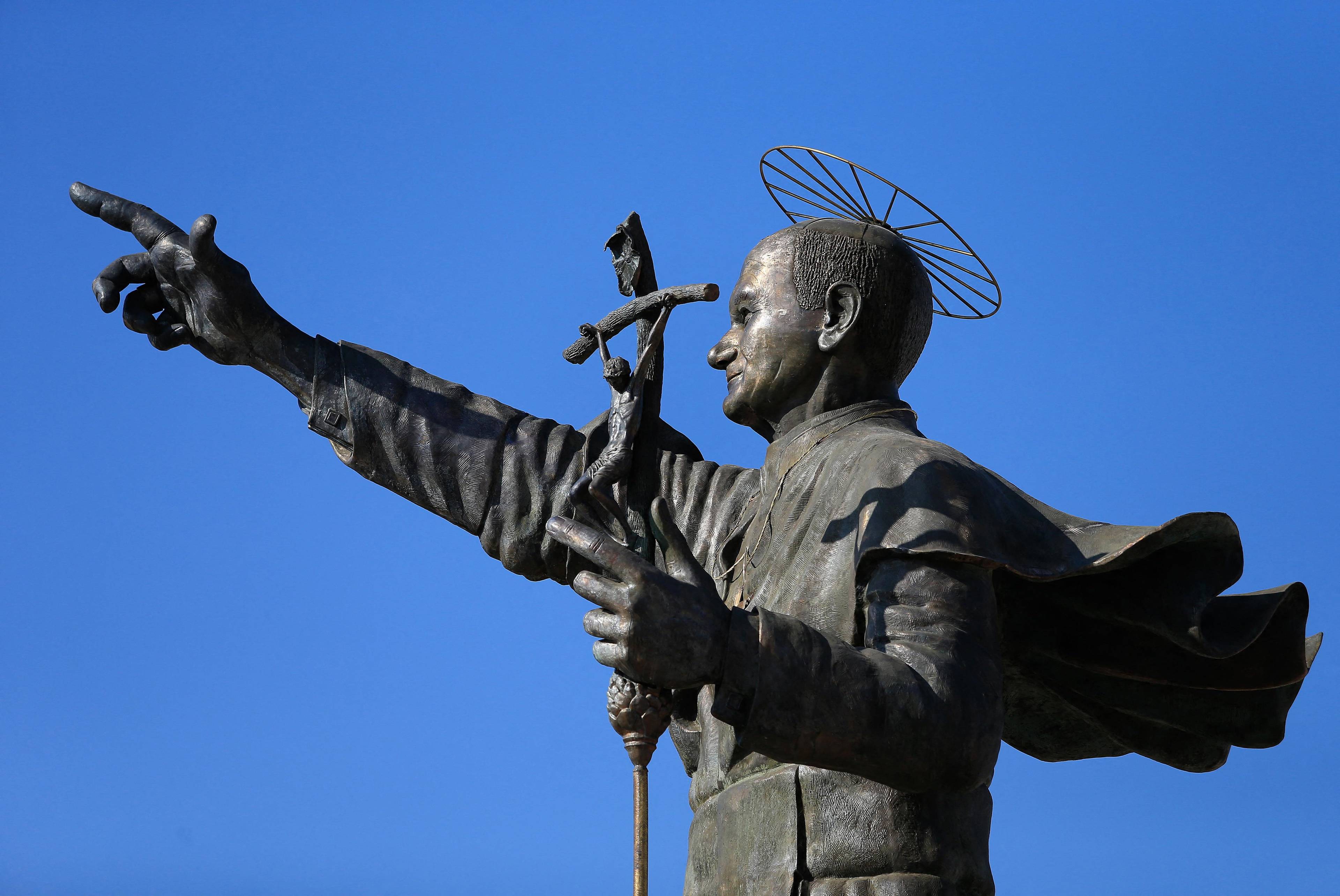 brązowy pomnik Jana Pawła II z wyciągniętą ręką, mało podobny