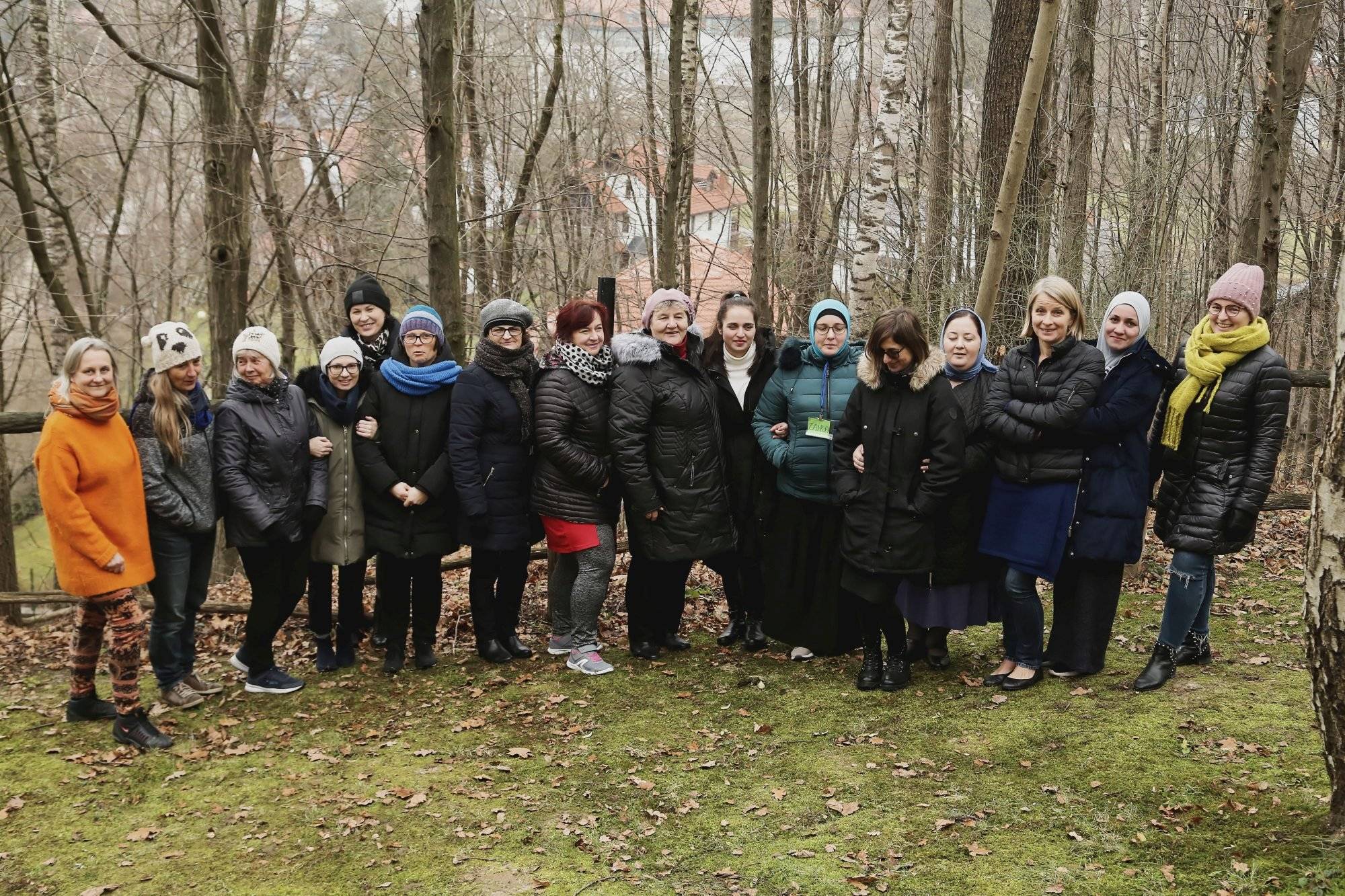 Grupa kobiet pozuje do zdjęcia na tle drzew