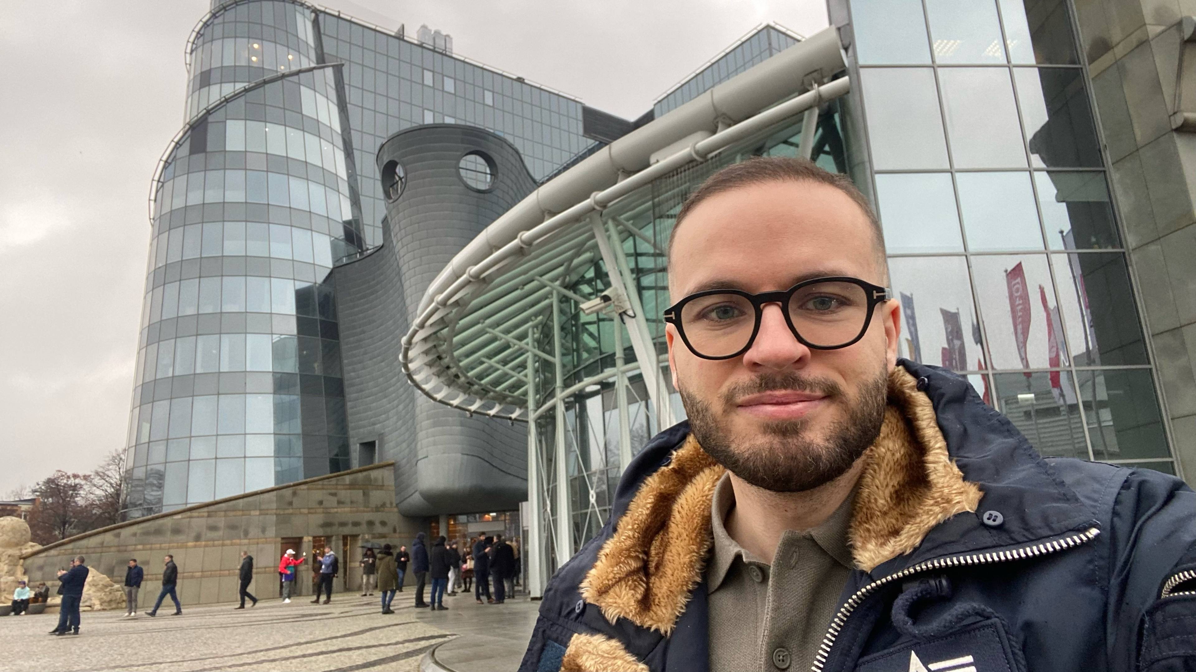 Bart Staszewski, aktywista LGBT, stoi przed budynkiem TVP na Woronicza