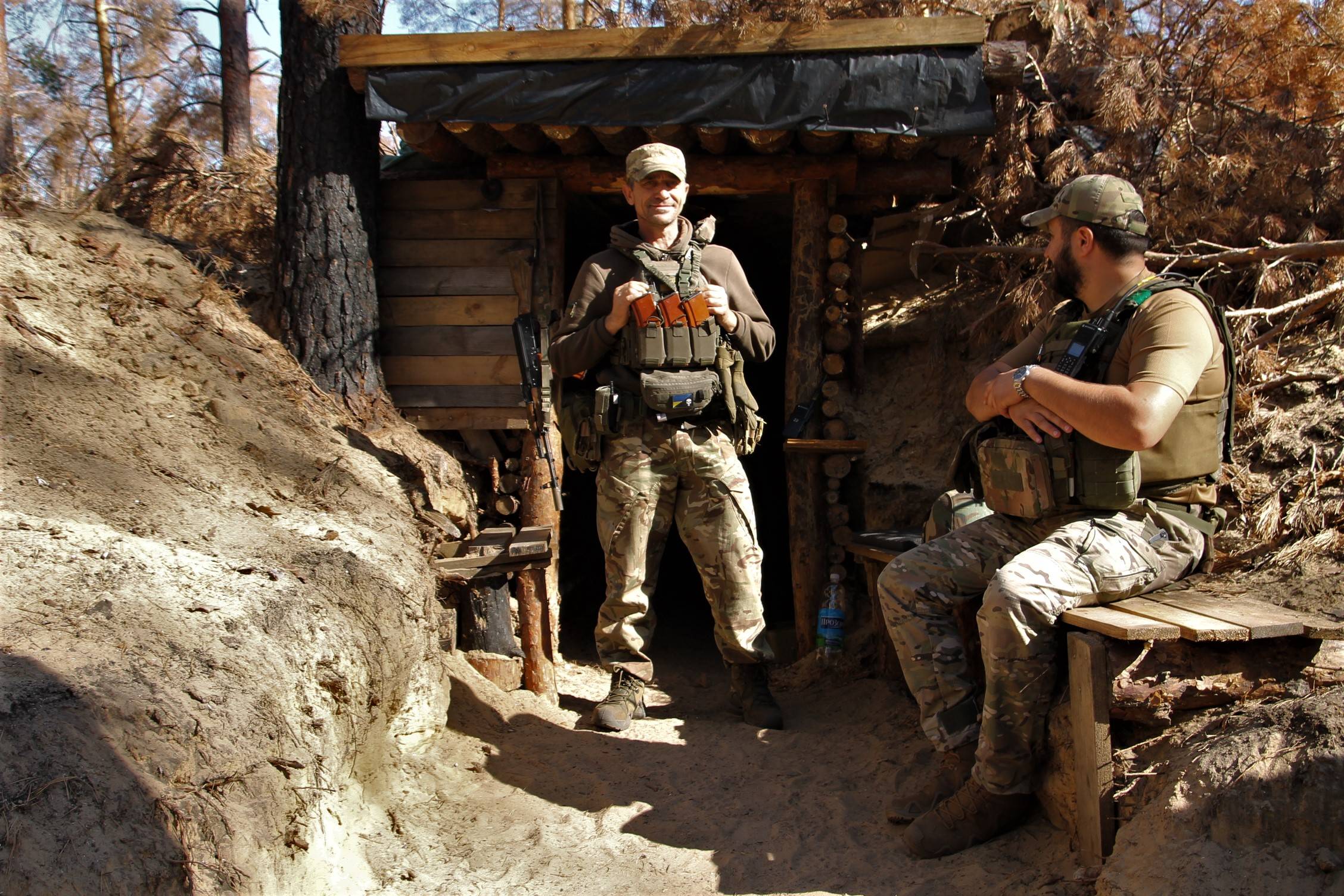 żołnierz w okopie, stoi przed ziemianką