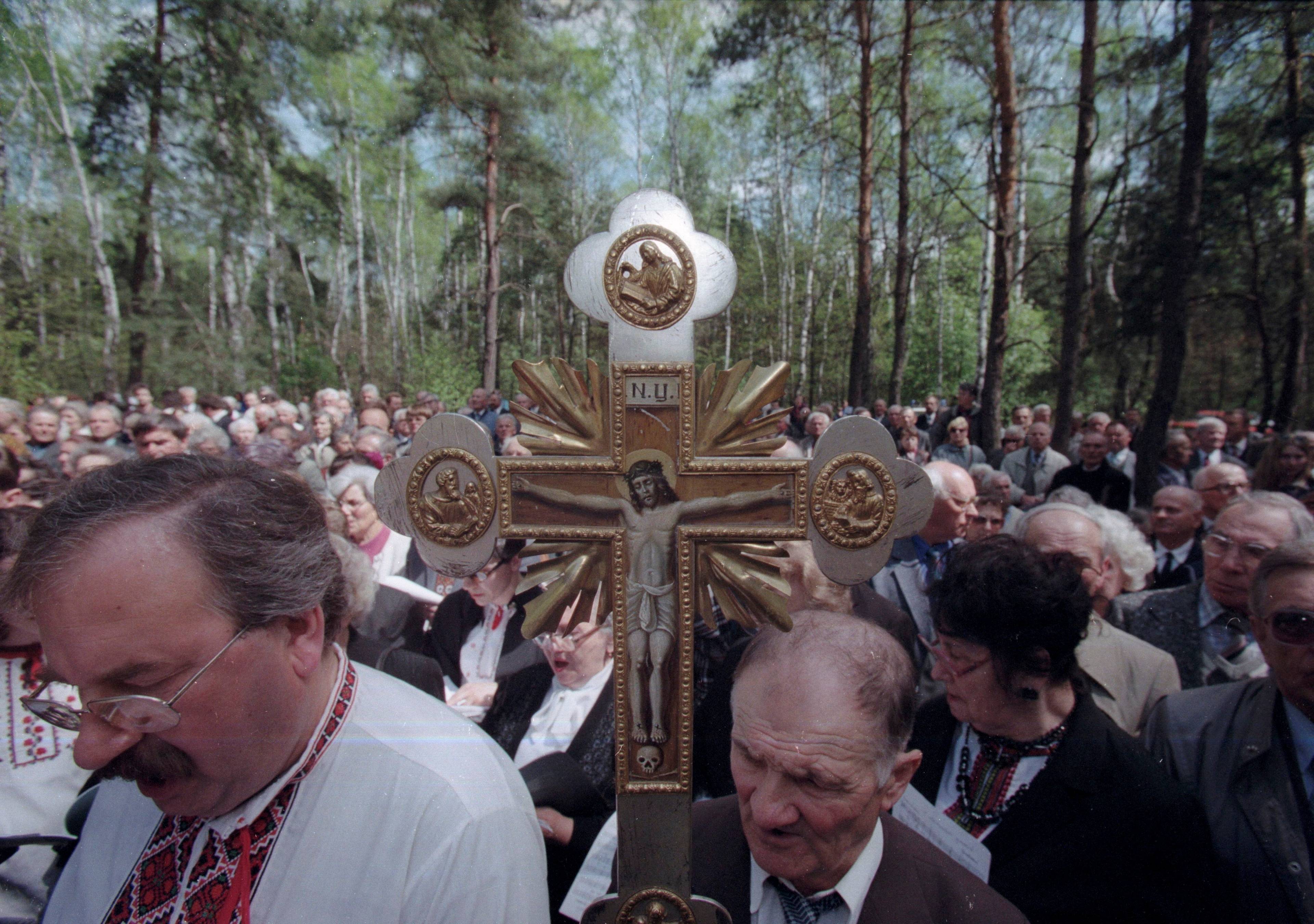 Ludzie w lesie zgromadzeni po prawosławnym krzyżem