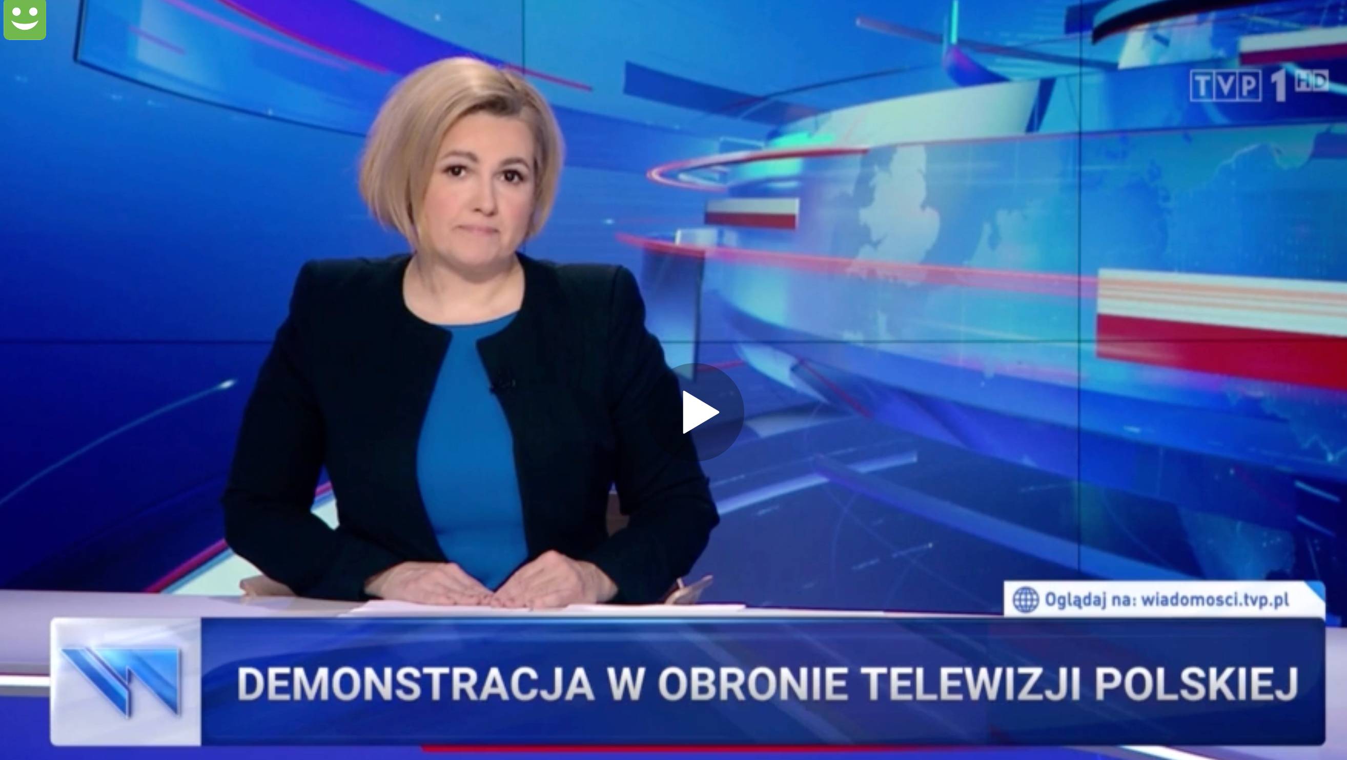 Spikerka telewizyjnych „Wiadomości” w studio, na dole ekranu pasek z napisem „Demonstracja w obronie telewizji”