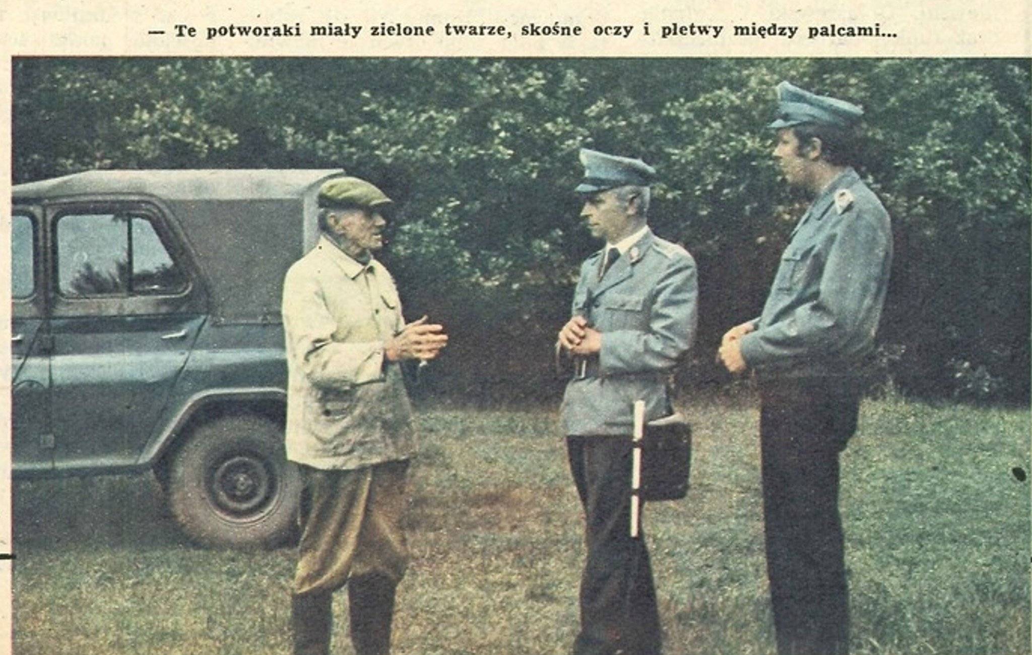 Zdjęcie archiwalne, Dwaj milicjanci w niebieskich mundurach, jeden z białą pałką przy boku słuchają starszego człowieka w gumiakach na nogach