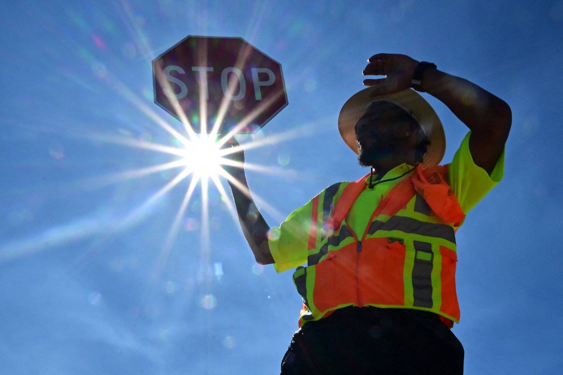 Traffic warden Rai Rogers mans his street corner during an 8-hour shift under the hot sun in Las Vegas, Nevada on July 12, 2023, where temperatures reached 106 degrees amid an ongoing heatwave. More than 50 million Americans are set to bake under dangerously high temperatures this week, from California to Texas to Florida, as a heat wave builds across the southern United States. (Photo by Frederic J. BROWN / AFP)