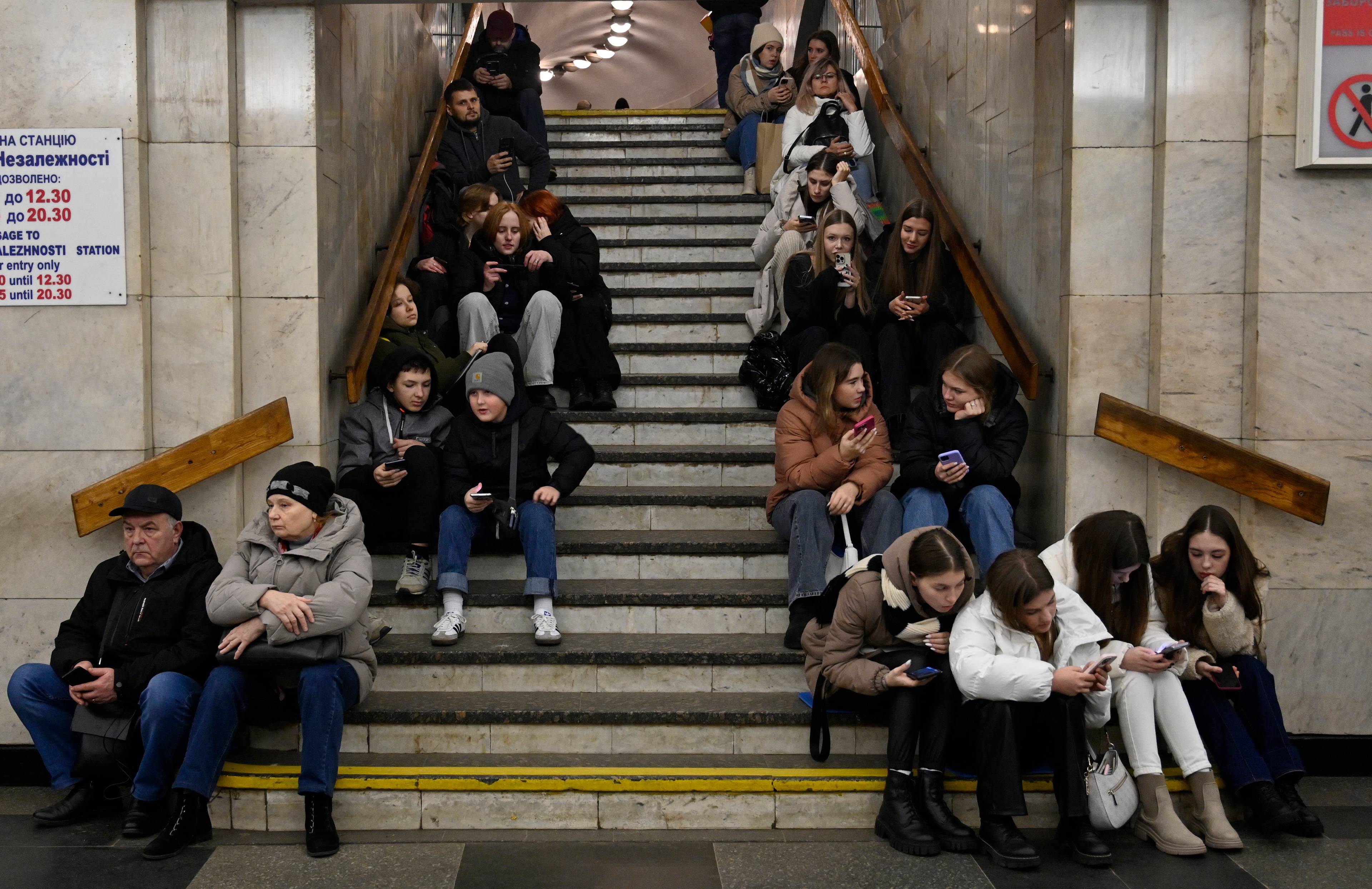 ludzie siedzący na schodach na stacji metra