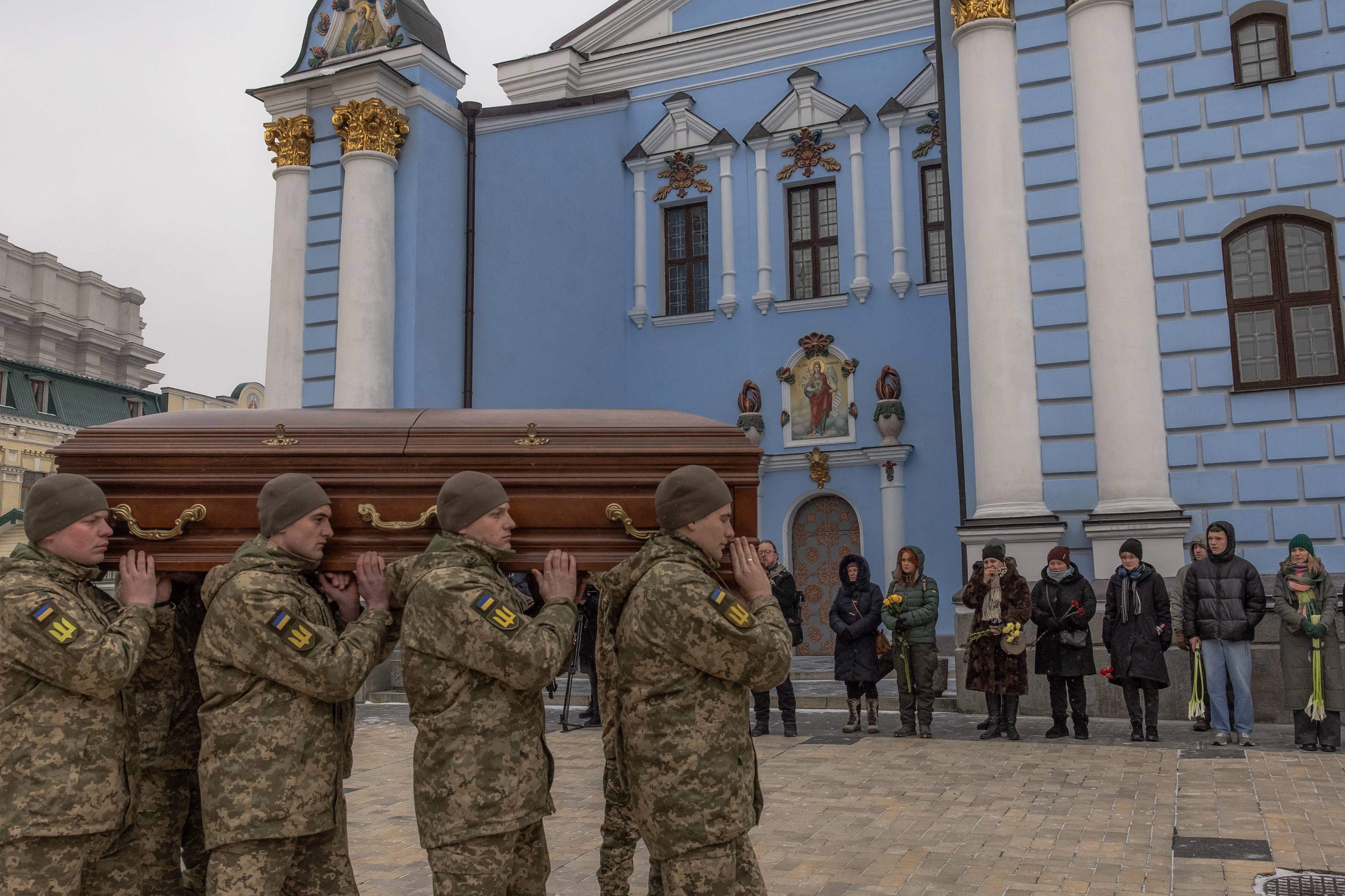 Żołnierze niosący trumnę przed cerkwią