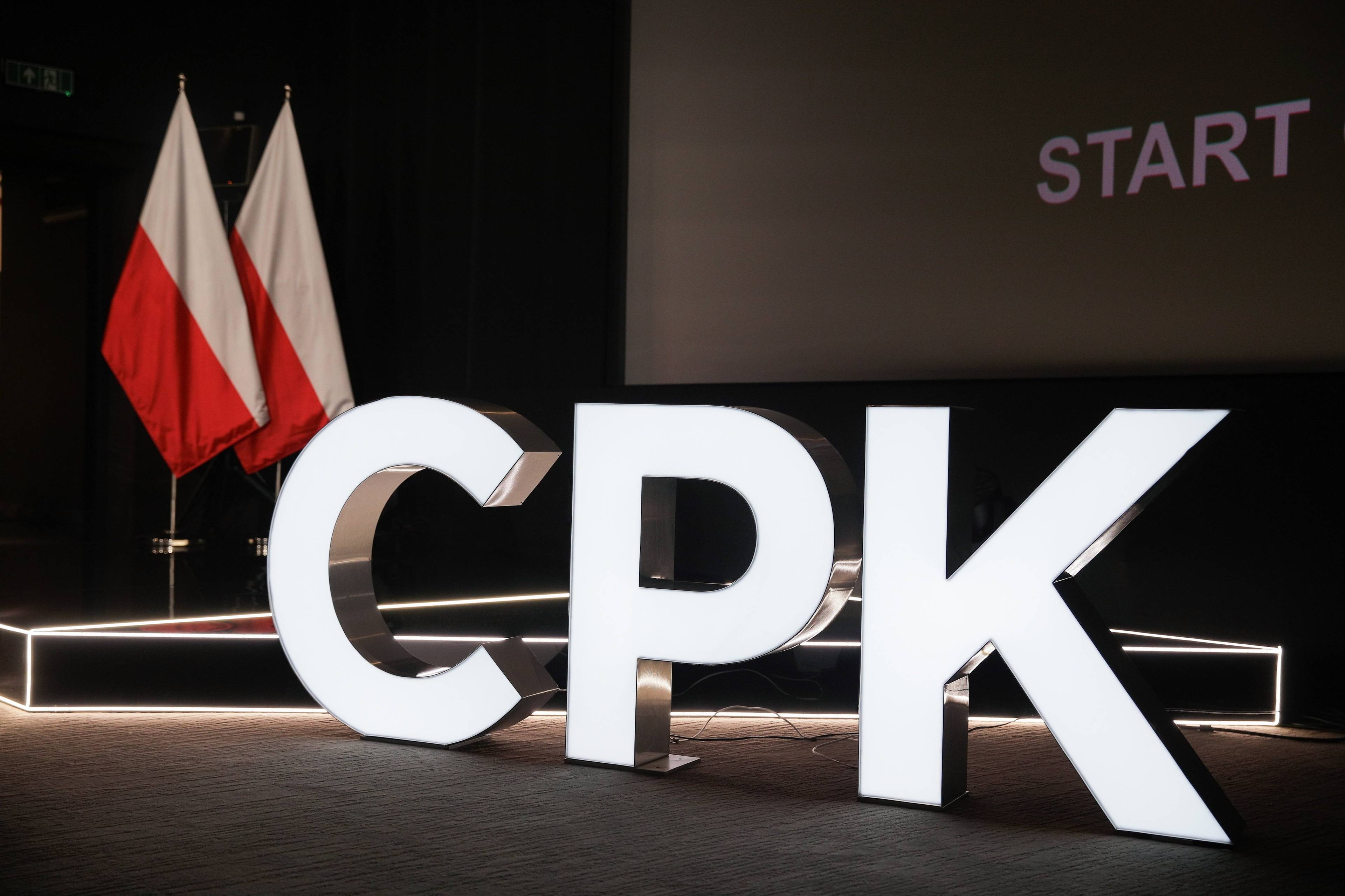 podświetlany napis "CPK" na tle polskich flag