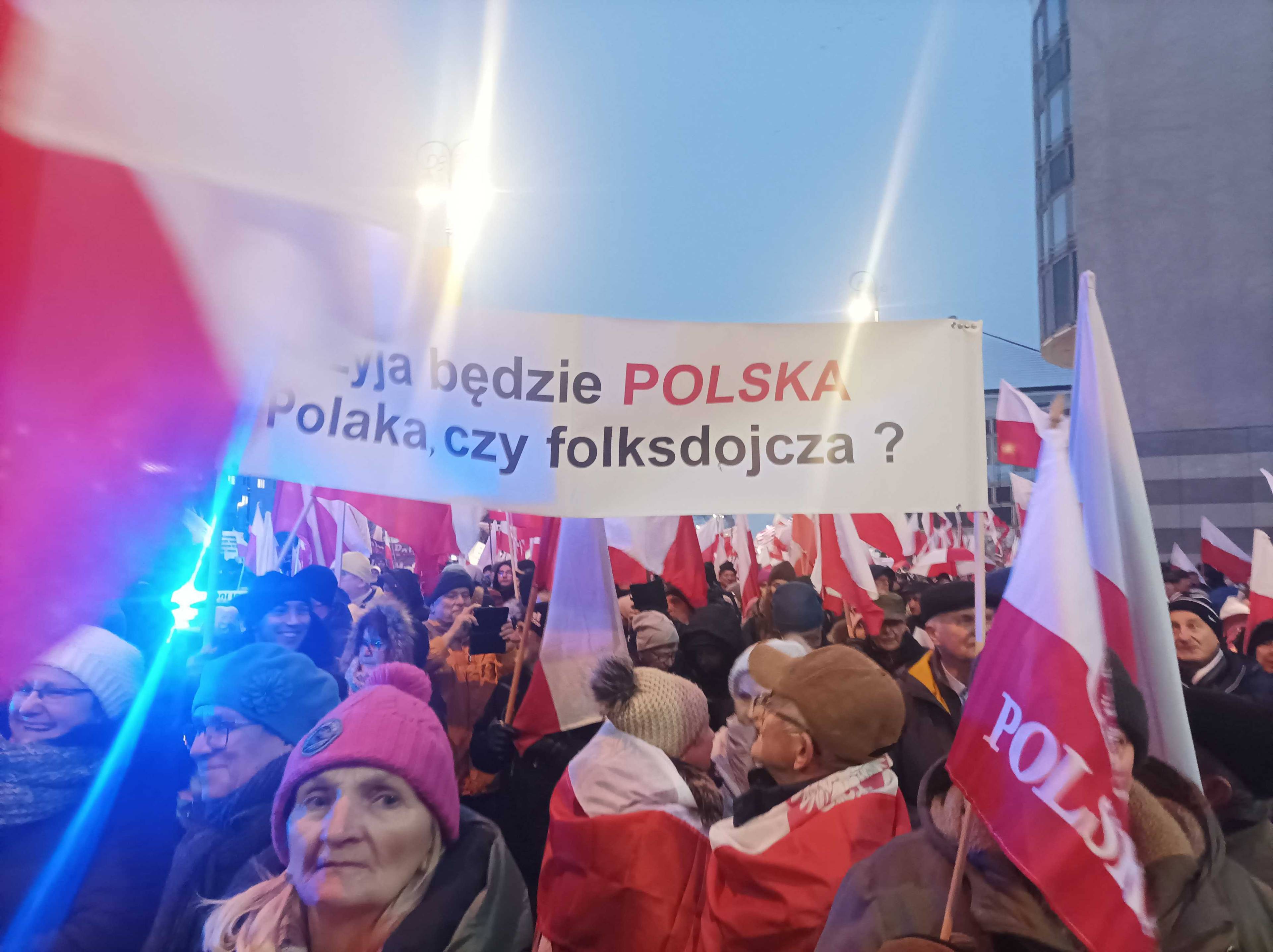 Uczestnicy marszu zwolenników PiS, który odbywa się w Warszawie 11 stycznia 2024 roku. Uczestnicy trzymają transparent z napisem "Czyja będzie Polska? Polaka czy folksdojcza?"