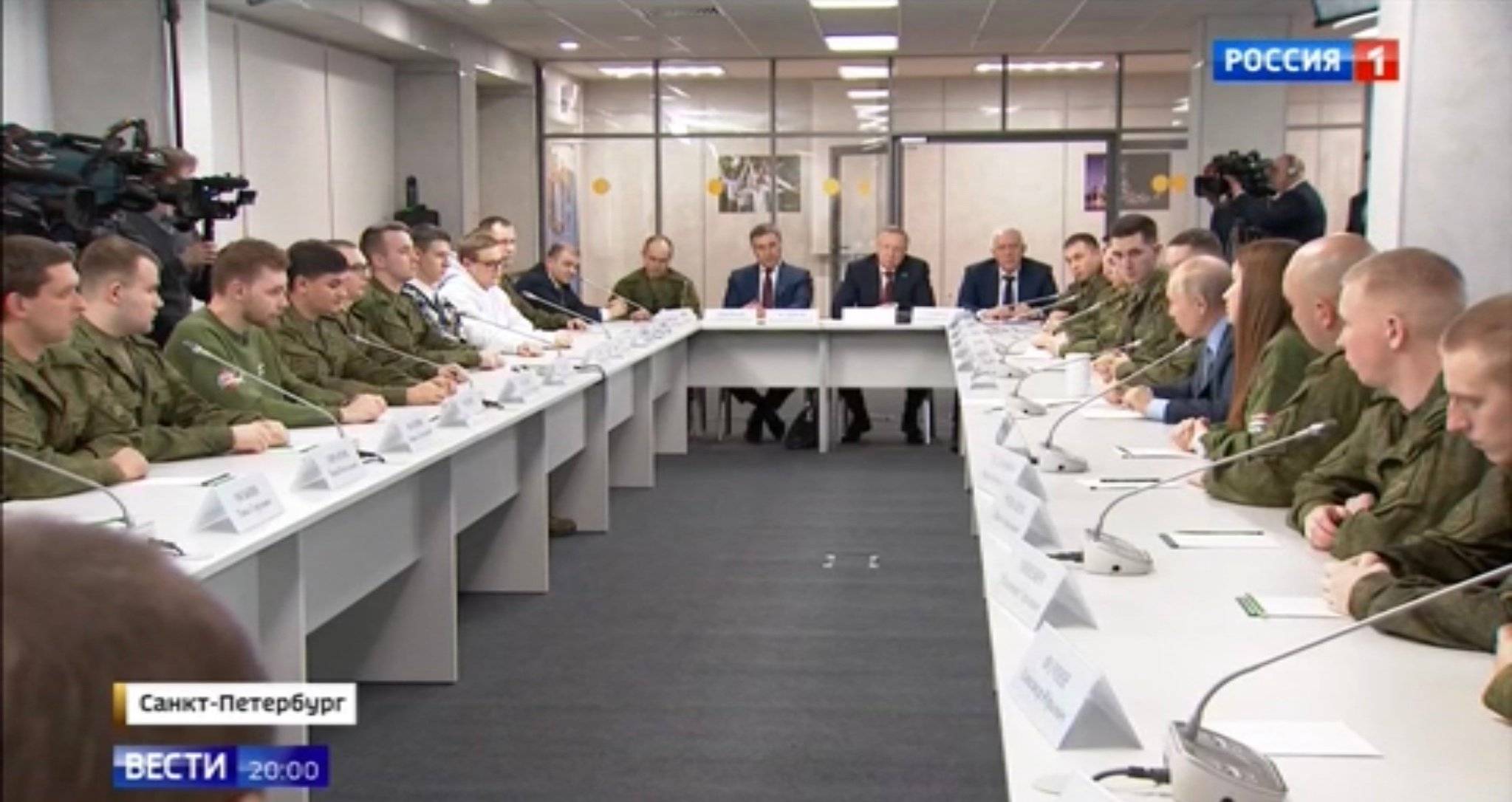 Putin i młodzi wojskowi siędzą dookoła prostokątnego stołu