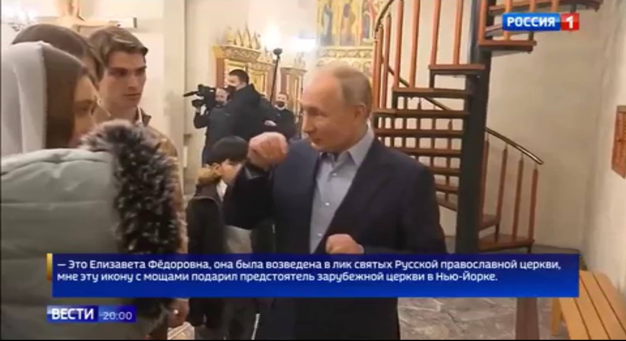 Putin w cerkwi gestykulije do dwóch chłopców. Napis po rosyjsku z tekstem jego wypowiedzi