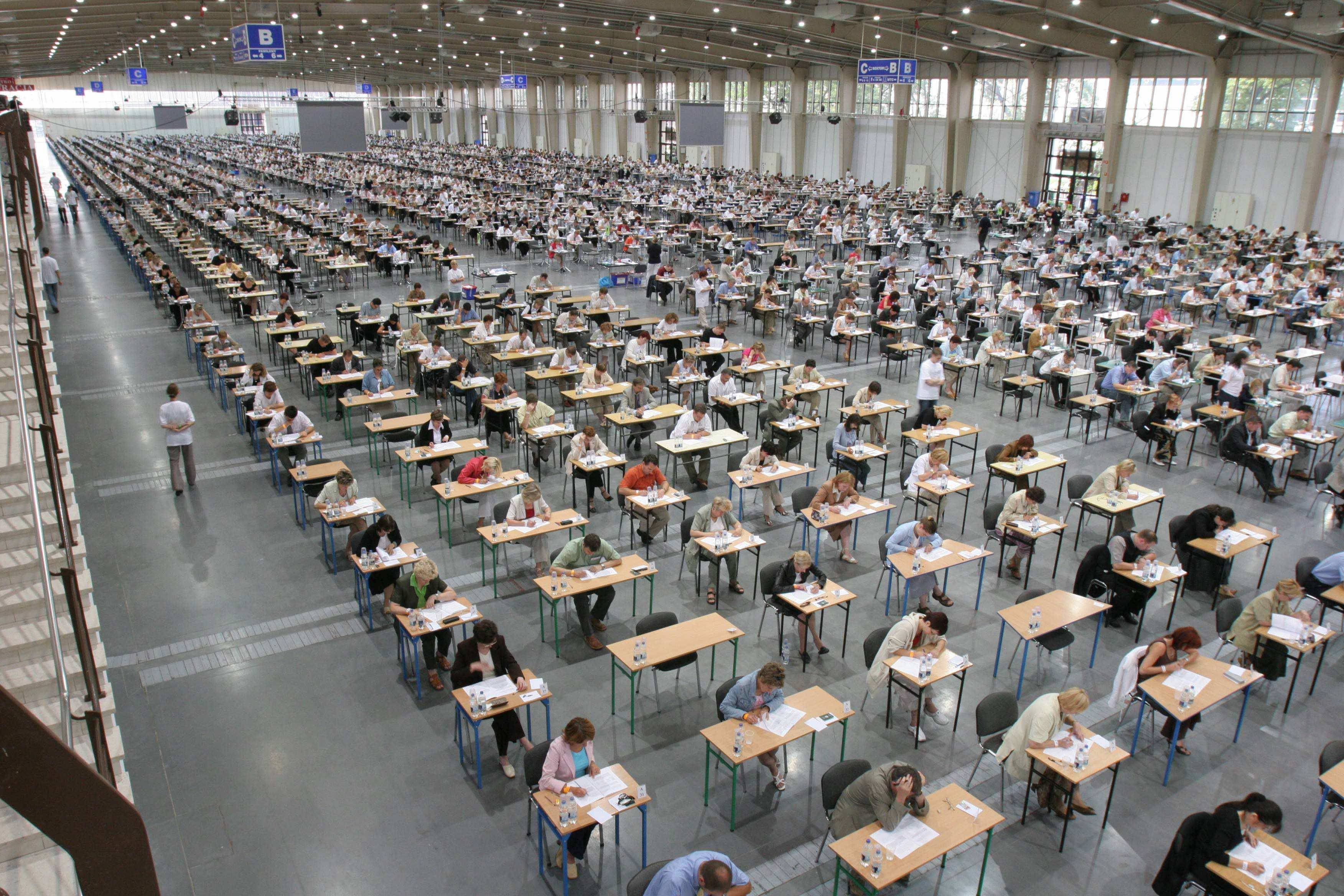Egzamin na służbę cywilną w hali Targw Poznańskich, setki stolików przy których siedzą kandydaci.
