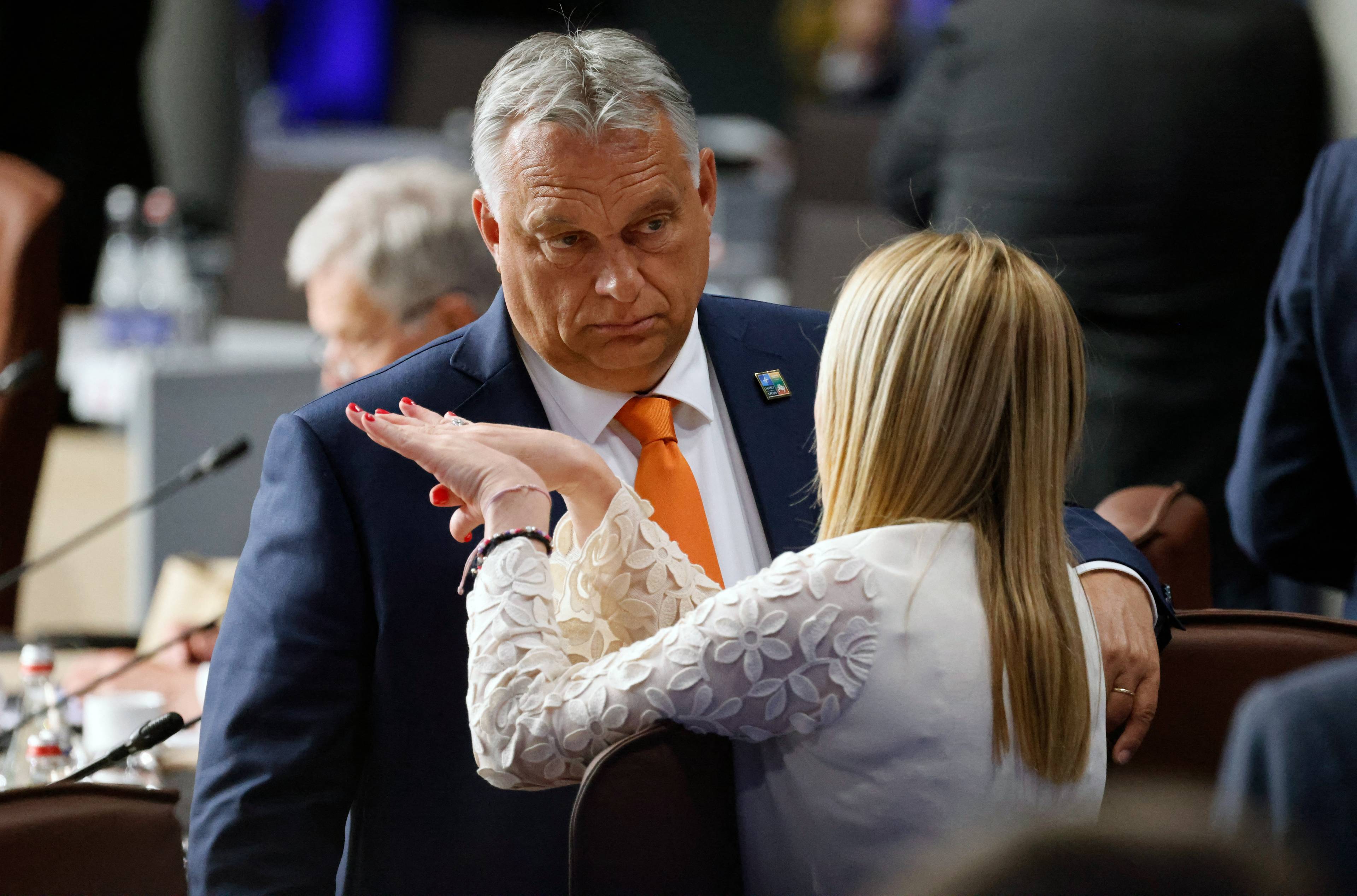 Gruby męzczyzna w pomarańczowym krawacie i jasnowłosa kobieta, która ostro gestykuluje. Orban i Melloni