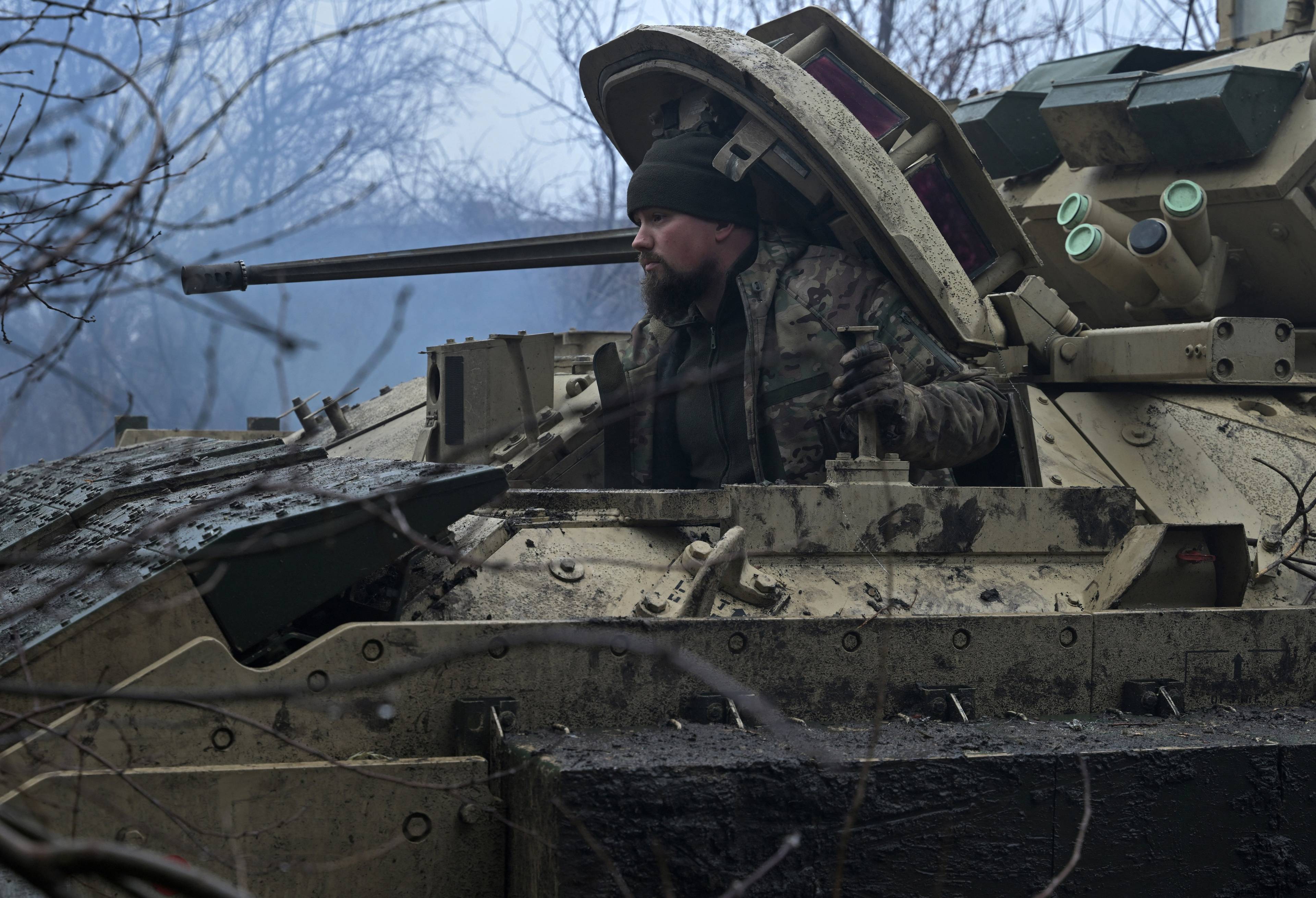 Ukraiński wygląda z podniesionego włazu pojazdu bojowego