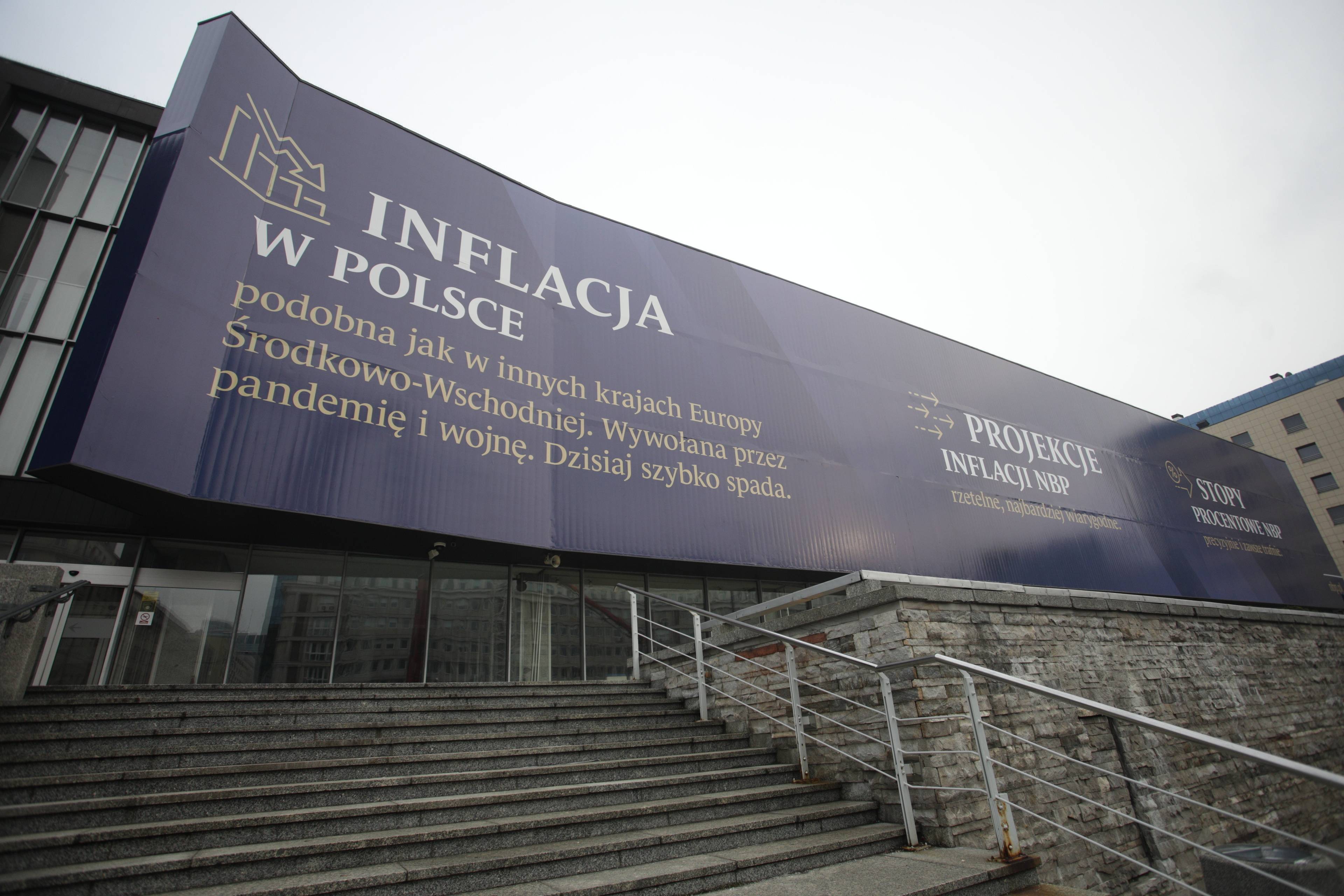 Baner na elewacji budynku Narodowego Banku Polskiego. Napis o inflacji: wywołana przez pandemie i wojnę ,dzisiaj szybko spada