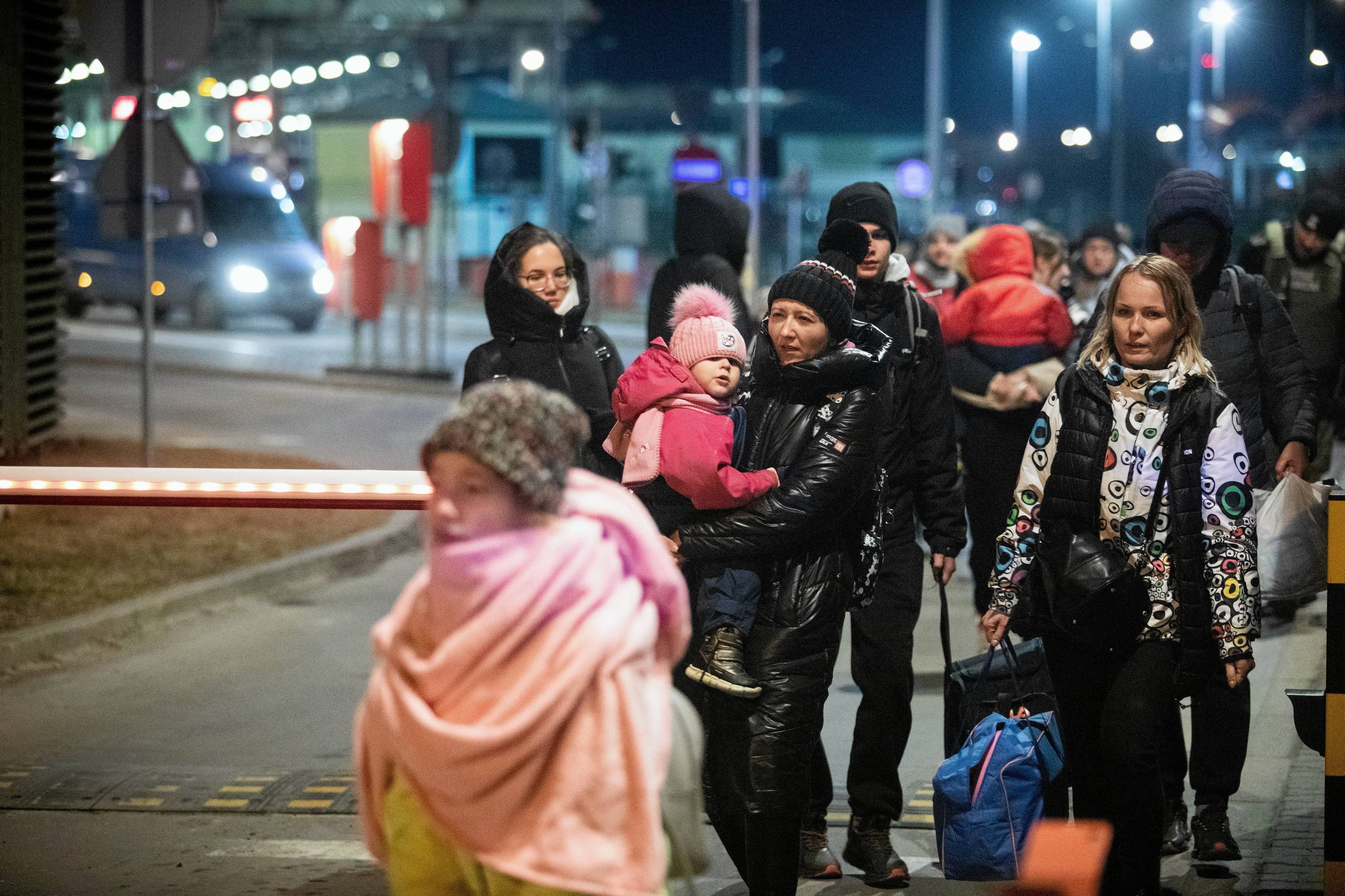 Kobiety i dzieci idą przez granicę
