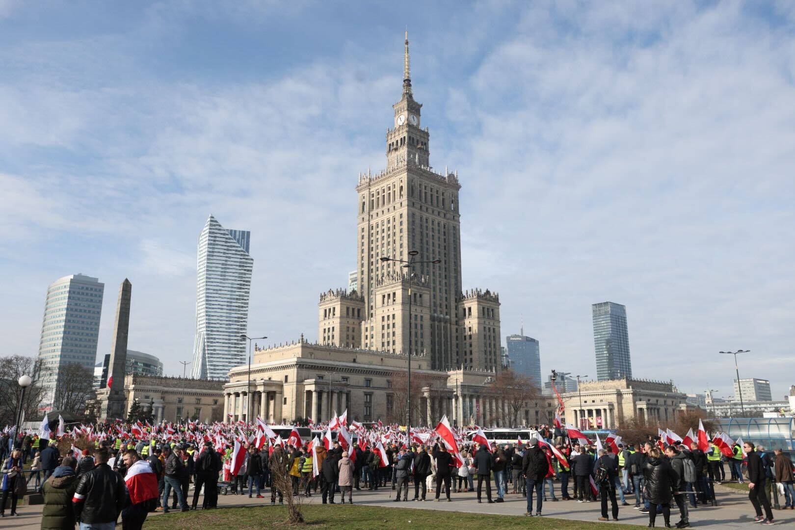 Zgromadzenie z biało-czerwonymi flagami pod Pałacem Kultury w Warszawie