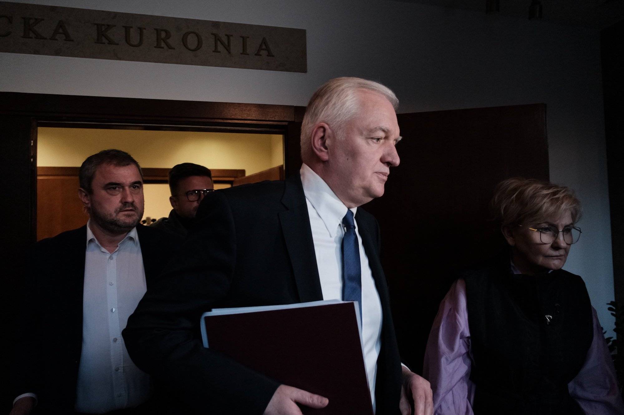 Jarosław Gowin wychodzi z jednej z sal w Sejmie. W ręku trzyma teczkę z dokumentami.