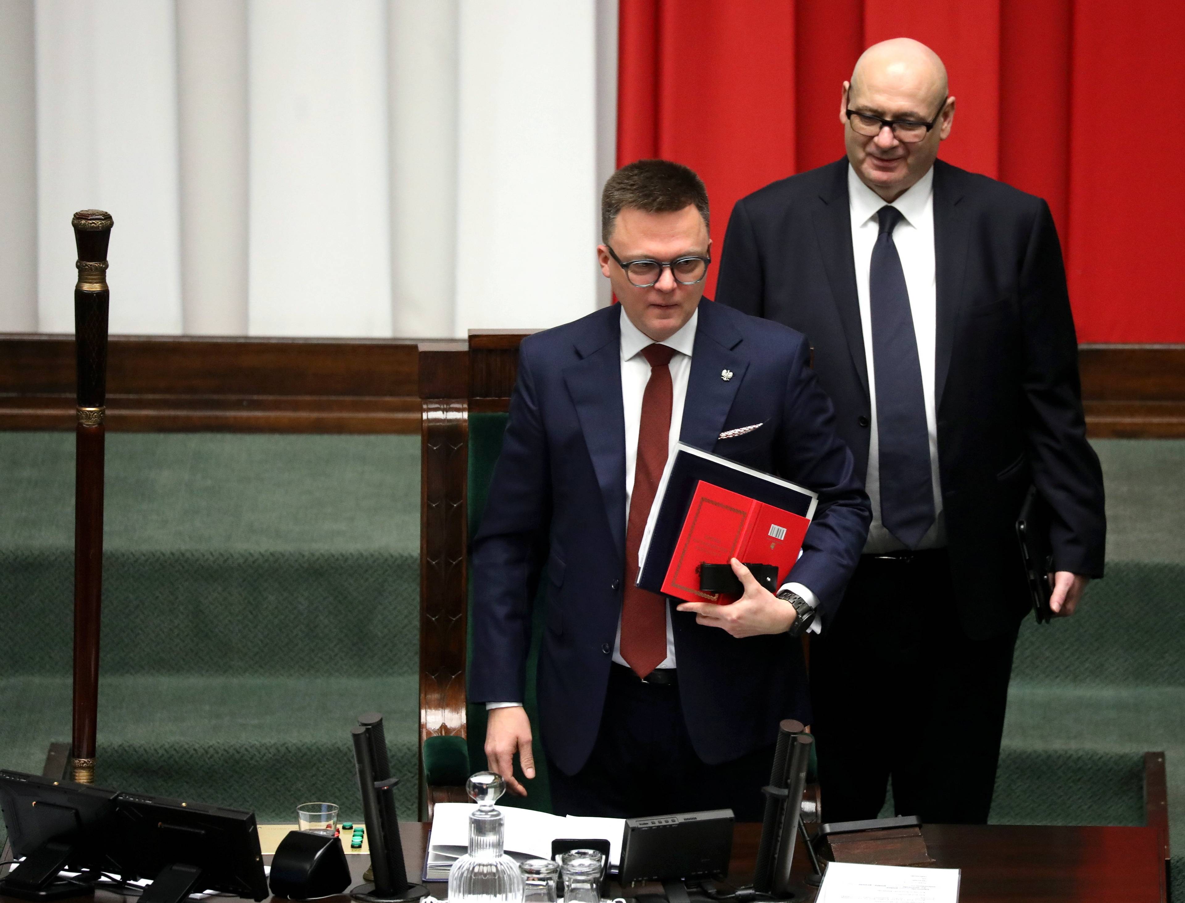 Marszałek Sejmu Szymon Hołownia z czerwoną teczką, z tyłu wicemarszałek Piotr Zgorzelski