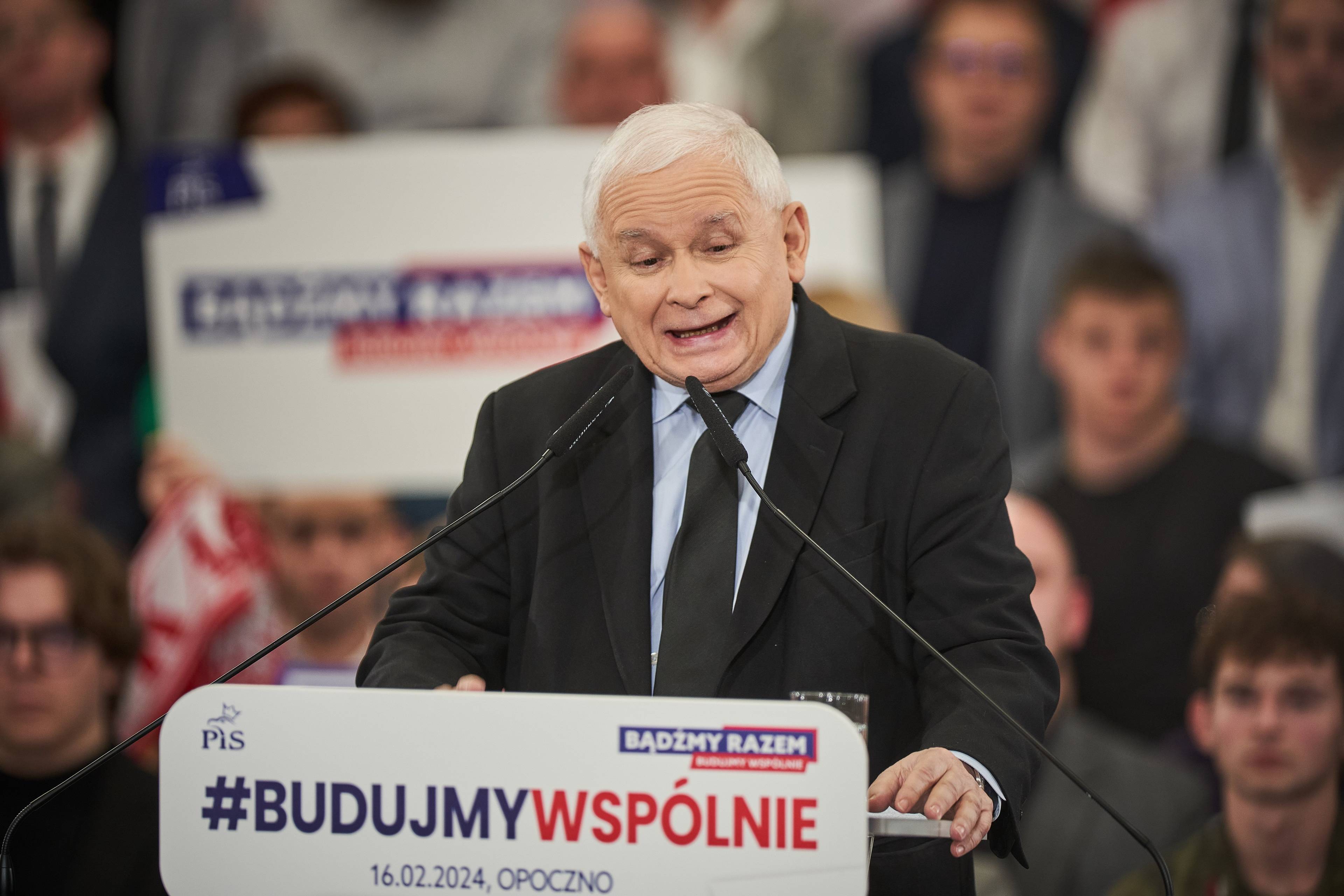 Jarosław Kaczyński przemawia. Na pulpicie napis #budujmywspólnie