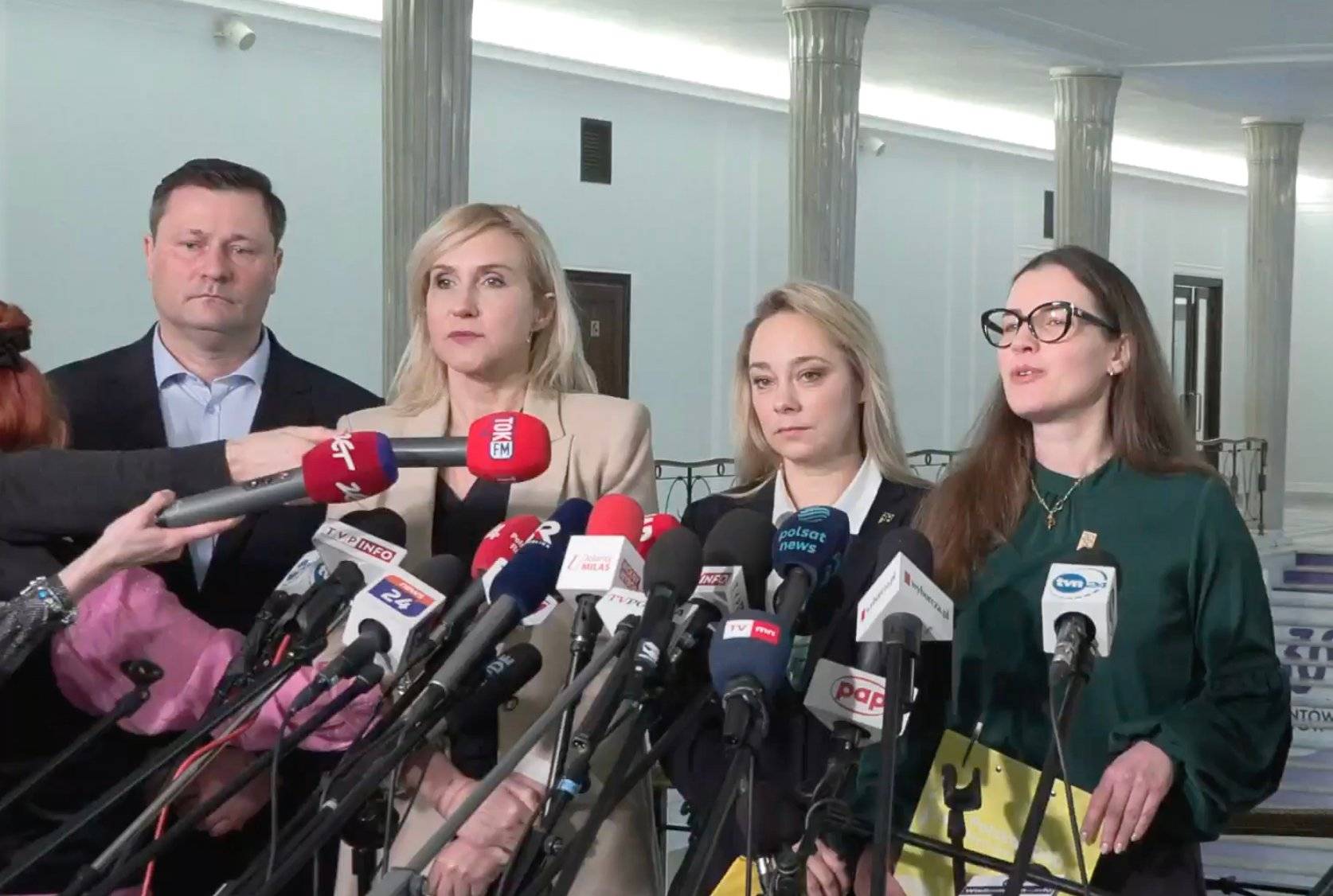 Mężczyzna i trzy kobiety stoją przed mikrofonami w holu Sejmu. Konferencja na temat projektu Trzeciej Drogi zmiany ustawy o aborcji