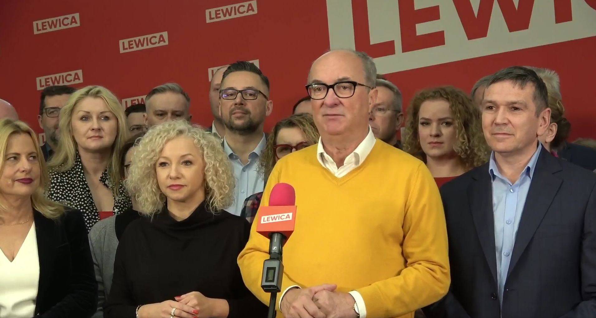 Włodzimierz Czarzasty, współprzewodniczący Lewicy stoi na scenie w gronie innych działaczy partii i przemawia na temat nadchodzących wyborów samorządowych