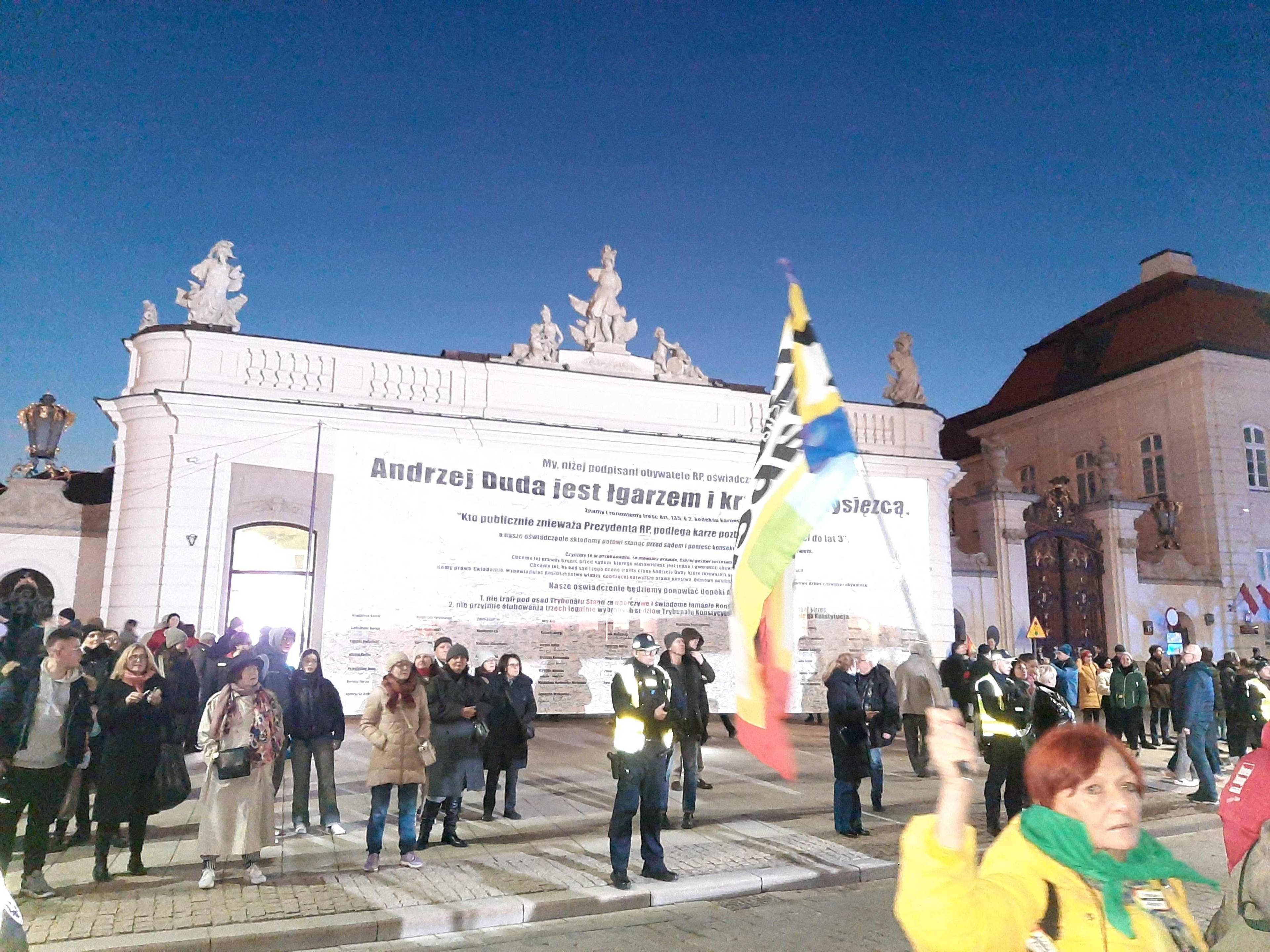 Aktywistki stoją na chodniku przed Pałacem Prezydenckim