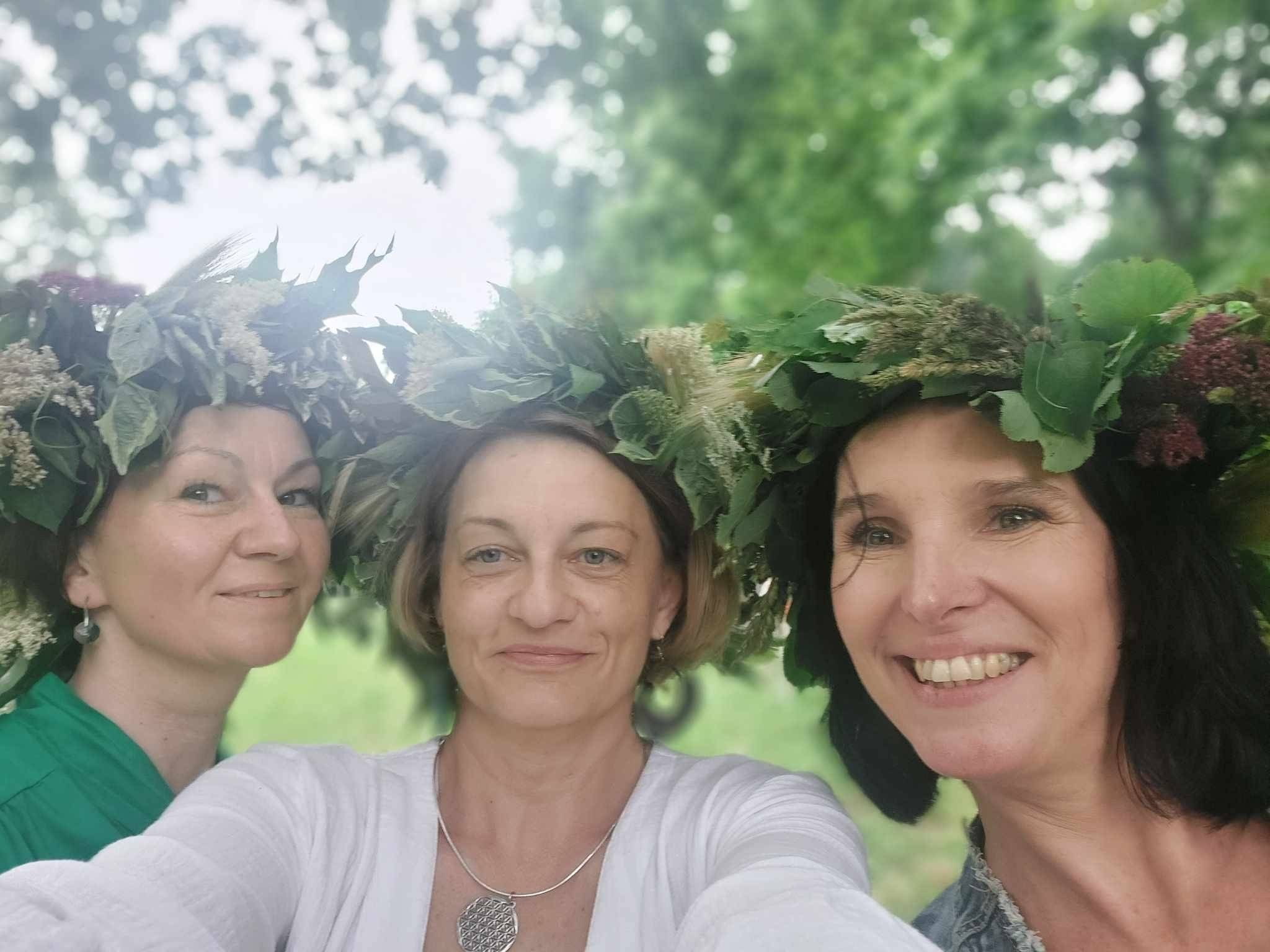 Trzy kobiety fotografują się w wiankach na głowie