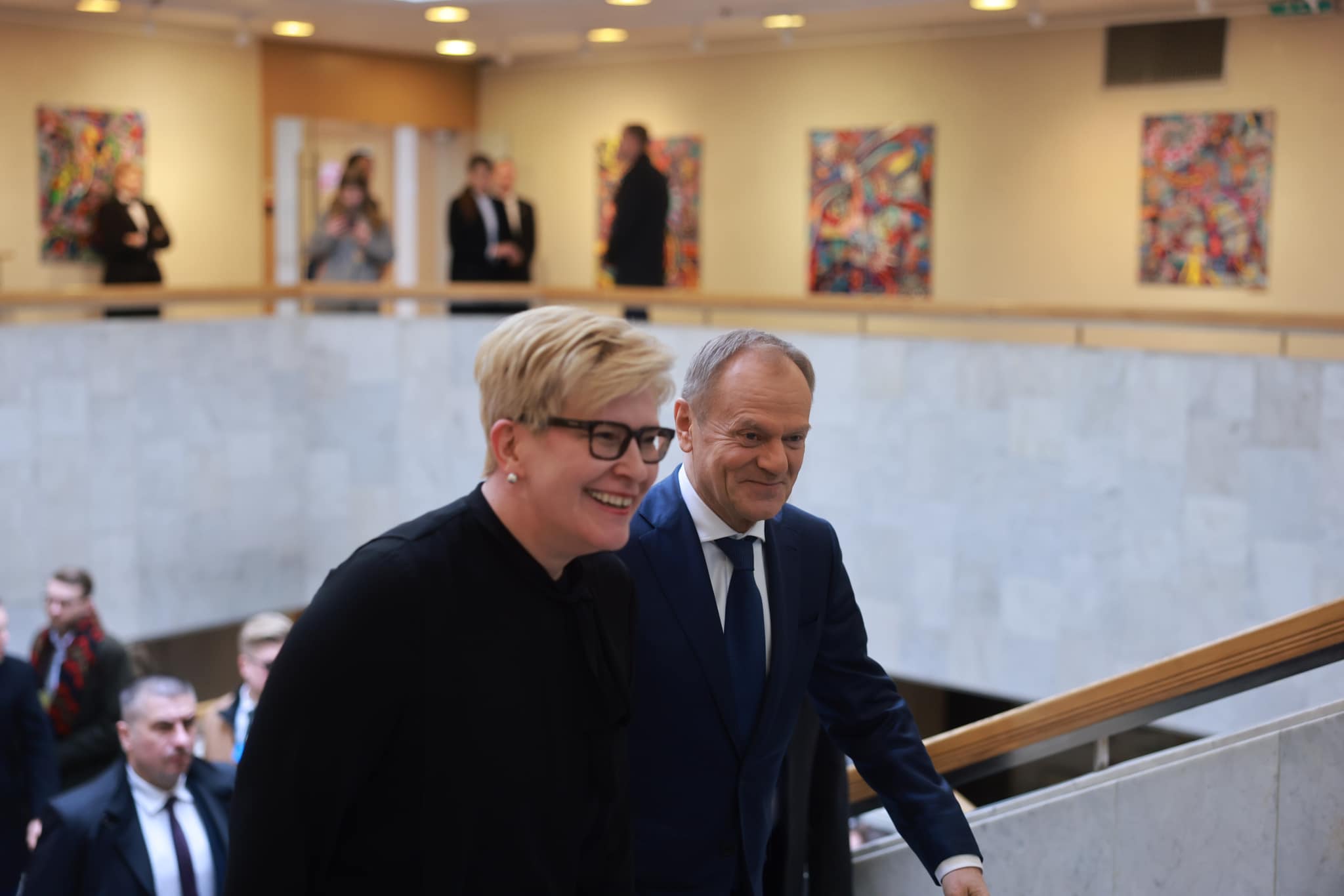 Usmiechnięci Donald Tusk i Ingrida Šimonytė wchodza po schodach