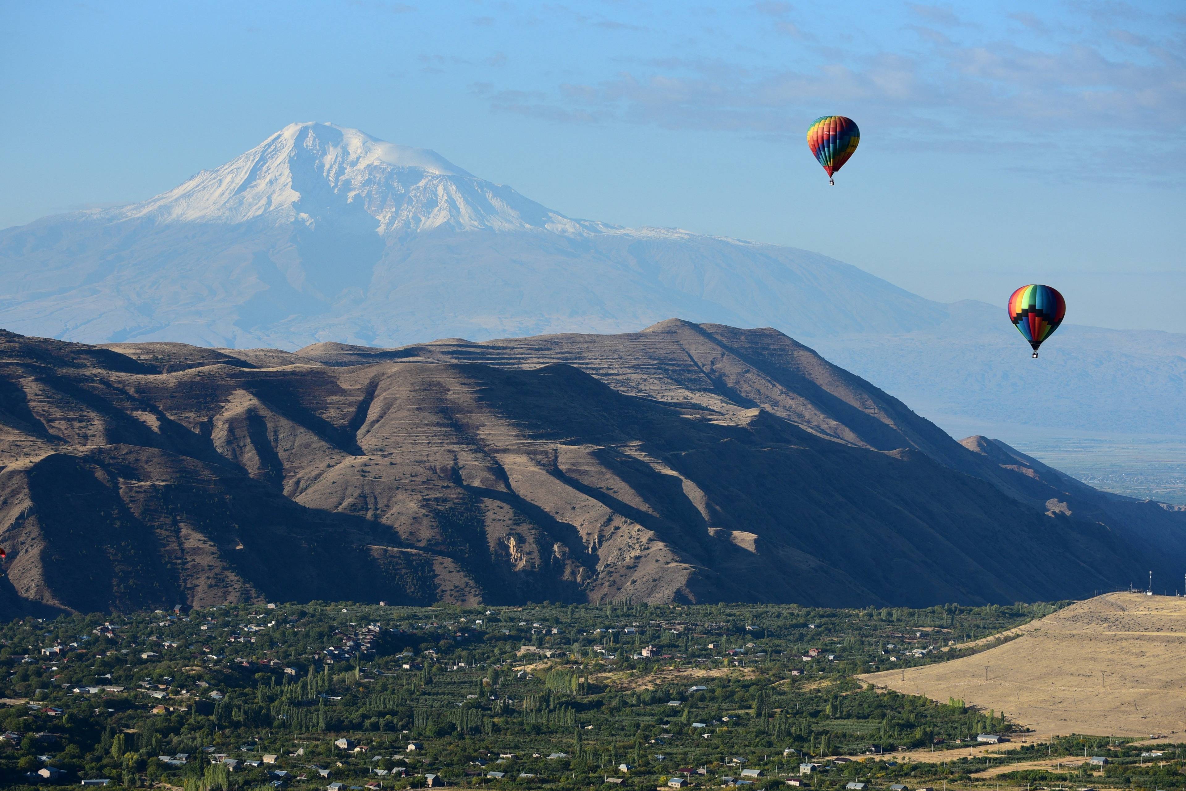 Ludzie podróżują balonami - w tle wysoka góra (Ararat)