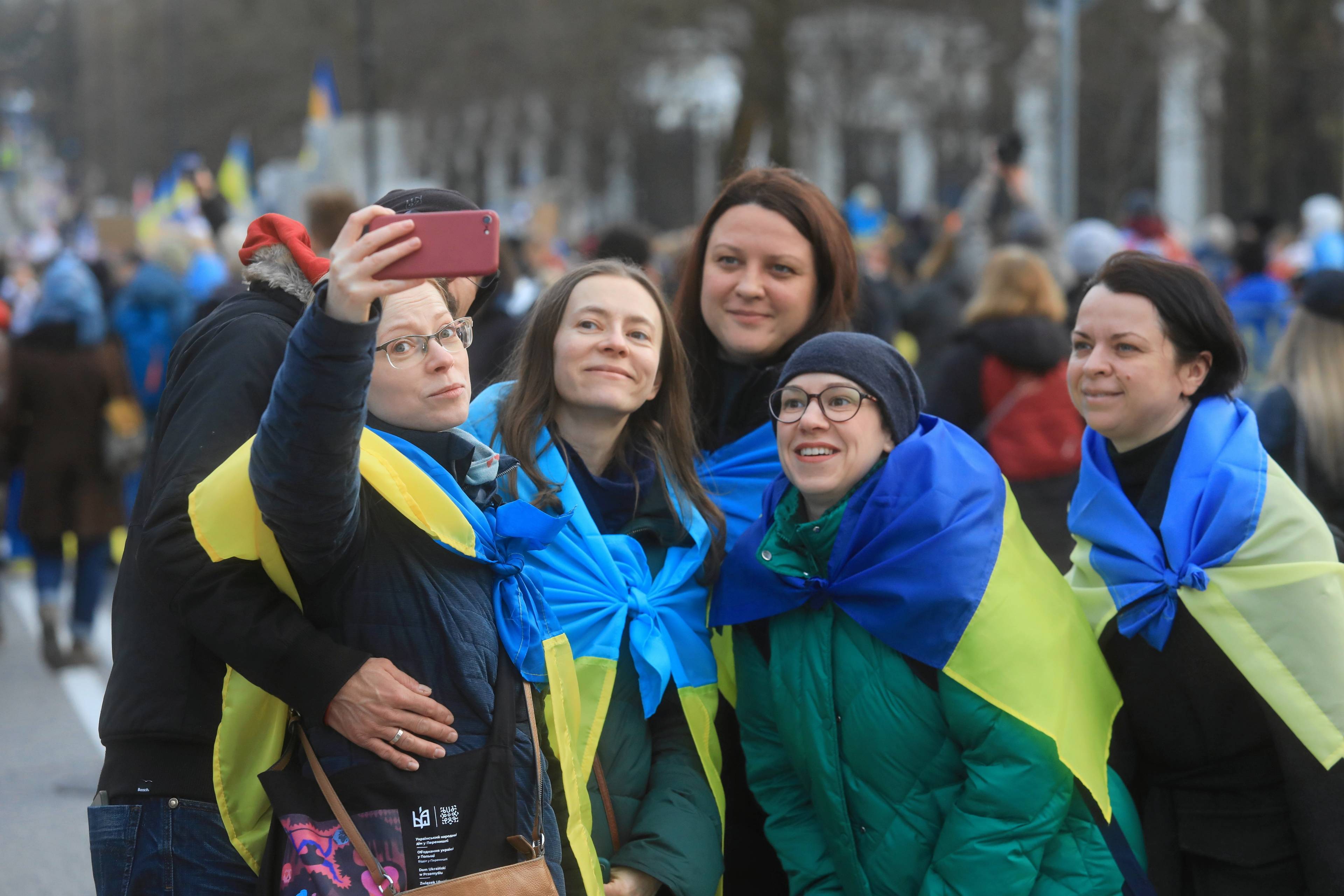 PIęć kobiet owiniętych we flagi ukrainy pozuje do wspólnego zdjęcia
