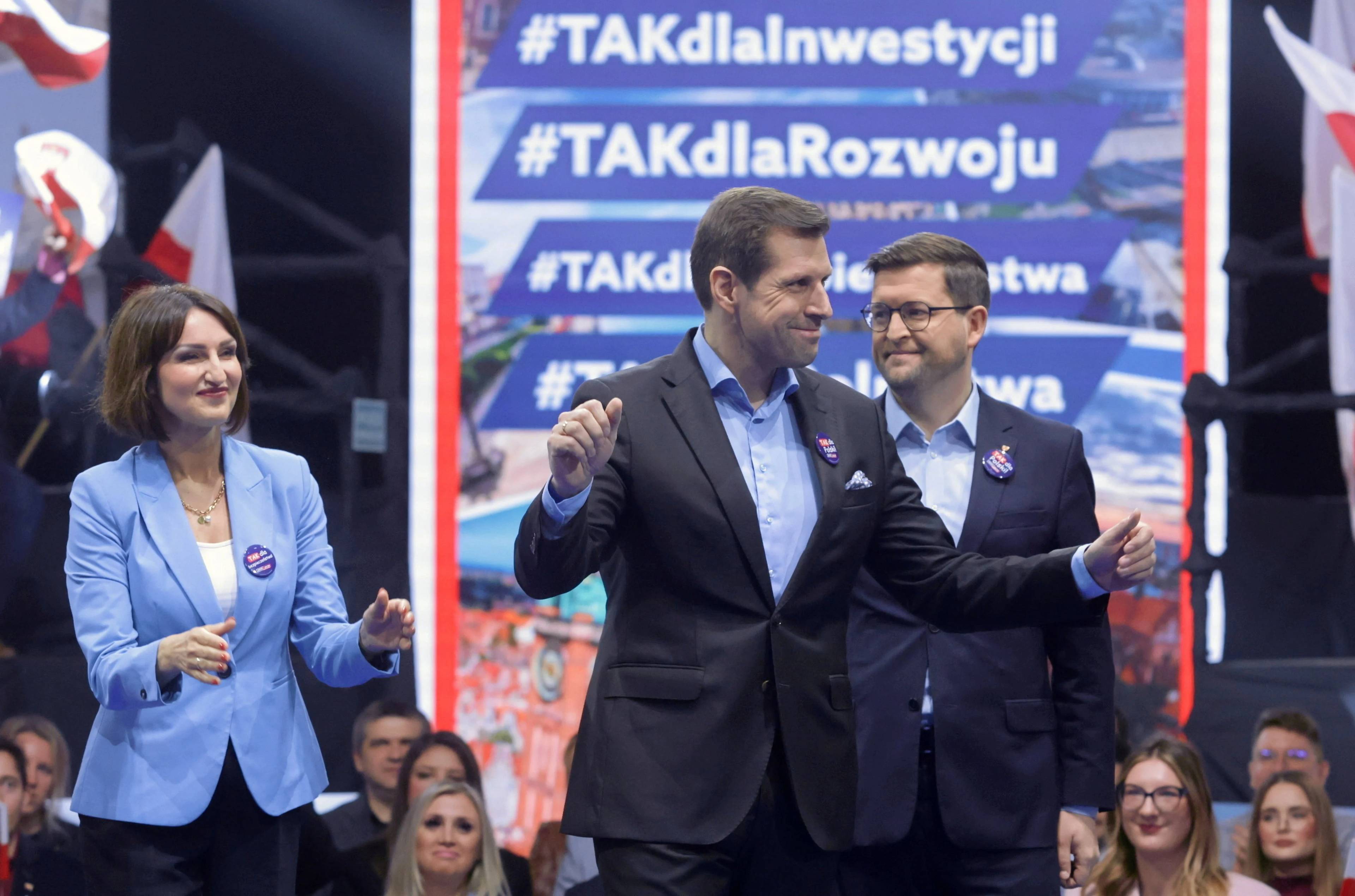 Kandydaci PiS w wyborach samorządowych uśmiechnięci stoją na scenie, na pierwszym planie Tobiasz Bocheński